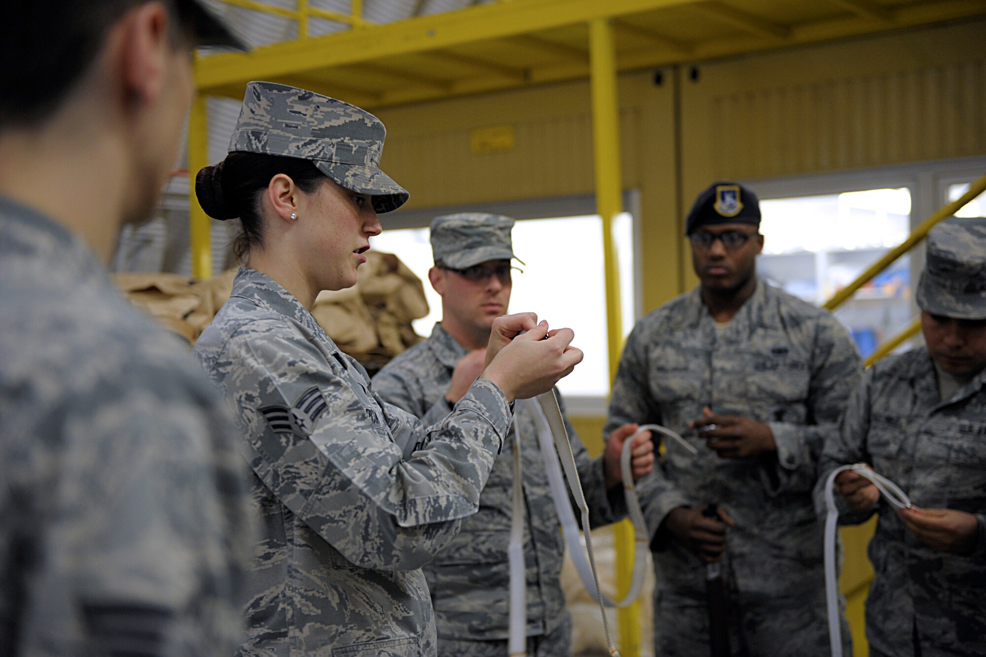 Senior Airman Senior Airman Amber Marcum, U.S. Air Force Honor Guard base honor guard program coordinator, demonstrates to Ramstein Honor Guard members how to ready a strap to attach to a ceremonial rifle March 15, 2016, at Ramstein Air Base, Germany. Members of the U.S. Air Force Honor Guard traveled to Ramstein to instruct base honor guardsmen on techniques to improve their color guard performances. (U.S. Air Force photo/Staff Sgt. Timothy Moore)