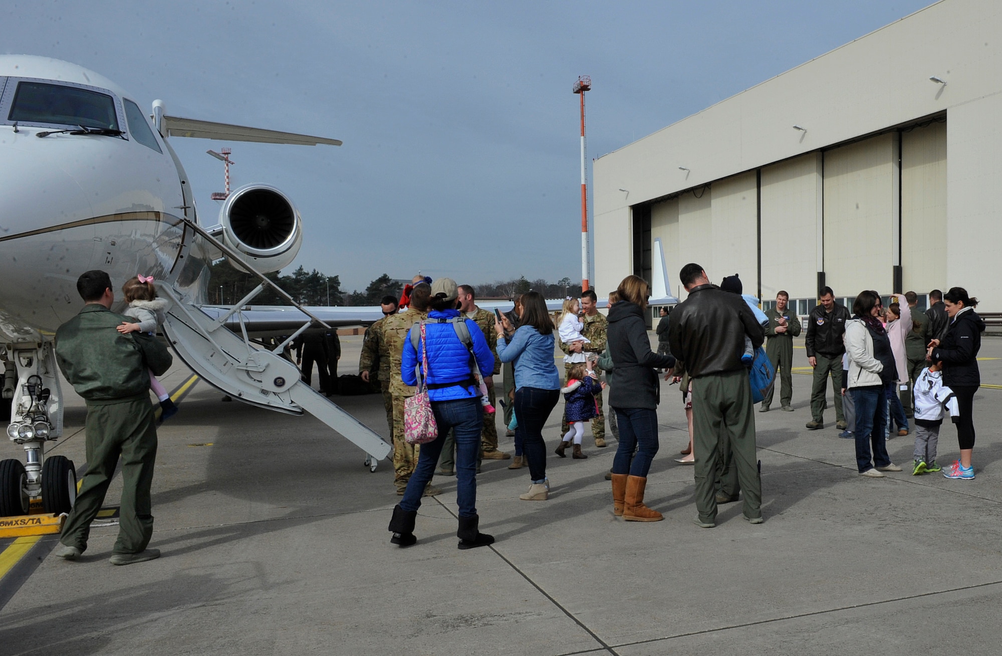 76th Airlift Squadron Airmen and family members greet each other during a welcome home event March 15, 2016, at Ramstein Air Base, Germany. The 76th AS provides combat assistance for an important mission six months out of the year. (U.S. Air Force photo/Airman 1st Class Larissa Greatwood)