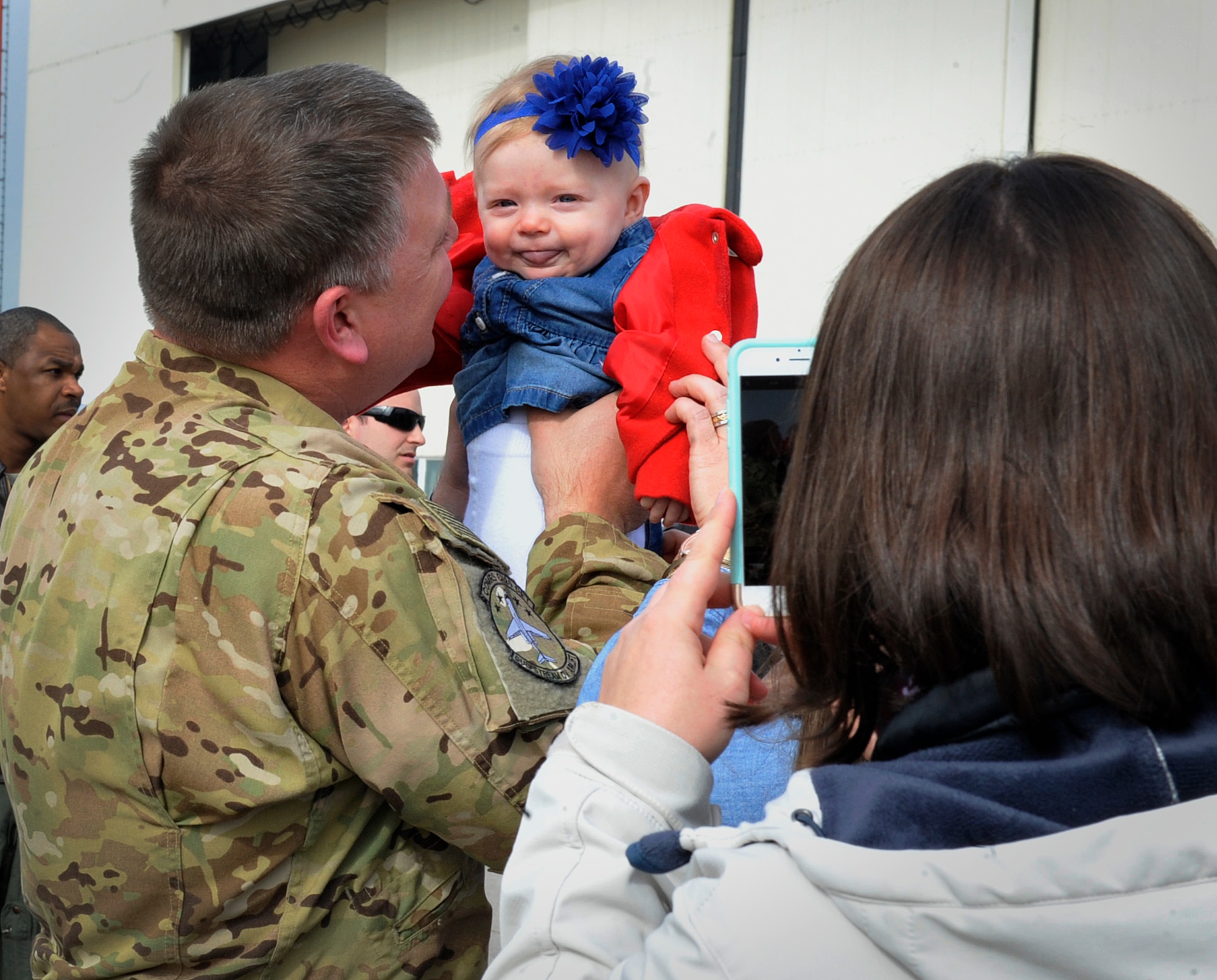 Maj. Thomas Chapman, 76th Airlift Squadron chief of training, holds his daughter after returning from a deployment March 15, 2016, at Ramstein Air Base, Germany. Spouses, children, friends and coworkers welcomed the Airmen home and thanked them for their commitment, sacrifice and dedication to the mission. (U.S. Air Force photo/Airman 1st Class Larissa Greatwood)