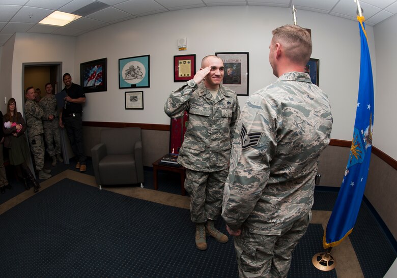 PETERSON AIR FORCE BASE, Colo. – Newly commissioned 2nd Lt. Evan J. List, former 21st Security Forces Squadron noncommissioned officer in charge of investigation, receives his first salute from longtime friend Staff Sgt. Darko Desancic in the Security Forces Squadron commander’s office at Peterson Air Force Base on March 17, 2016. List just completed Officer Training School and will be heading to Vandenberg AFB, California for technical training, marking the first time both Airmen have been stationed without one another in their Air Force careers. (U.S. Air Force photo by Airman 1st Class Dennis Hoffman)