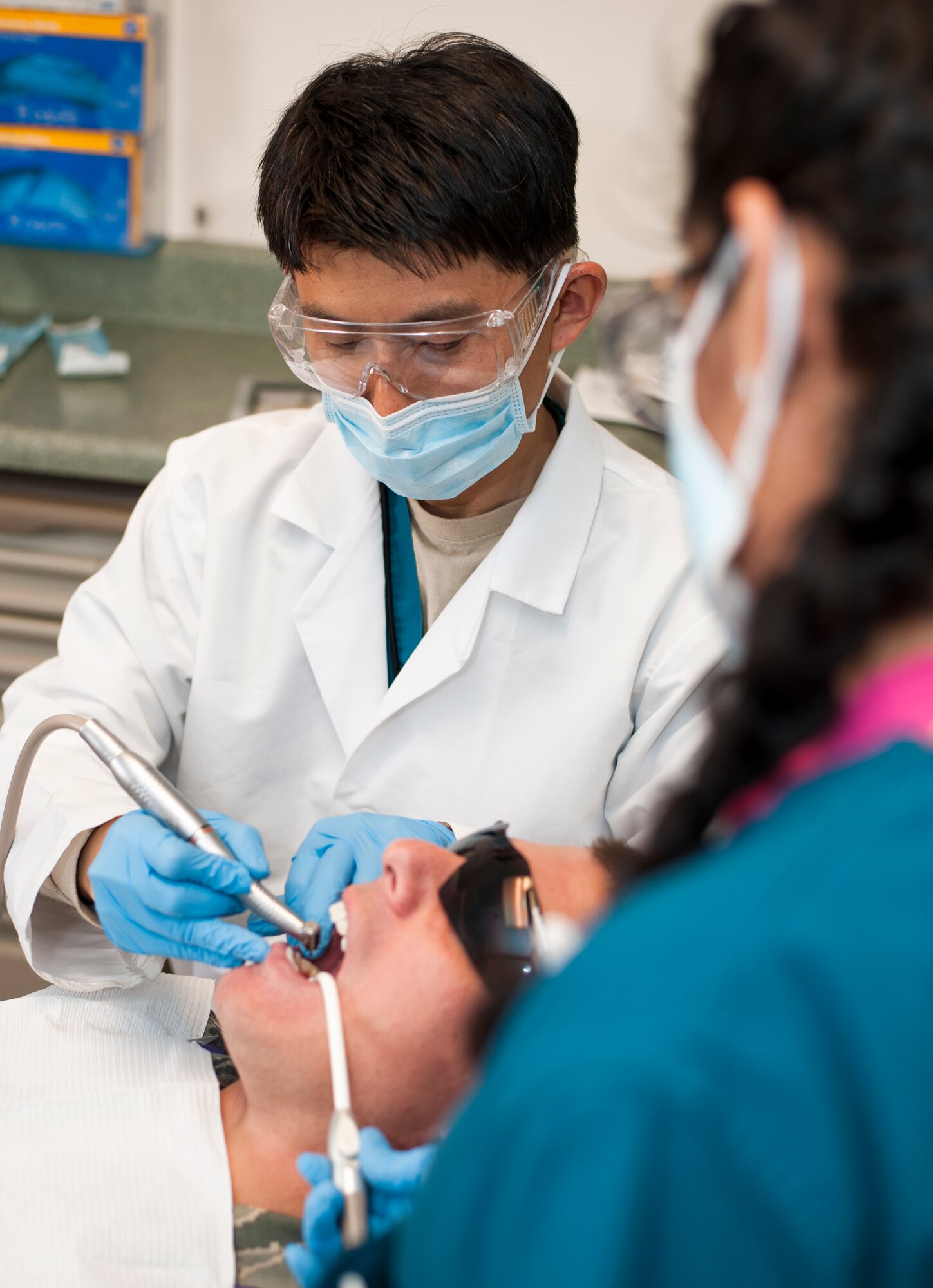 PETERSON AIR FORCE BASE, Colo. -Lt. Col. Brett M. Chung, Peterson Dental Clinic professional services chief, examines a patient at the dental clinic here March 22, 2016. After first joining the U.S. Navy, Chung left in 2006 as a lieutenant commander and the very next day entered the Air Force. (U.S. Air Force photo by Airman 1st Class Dennis Hoffman)