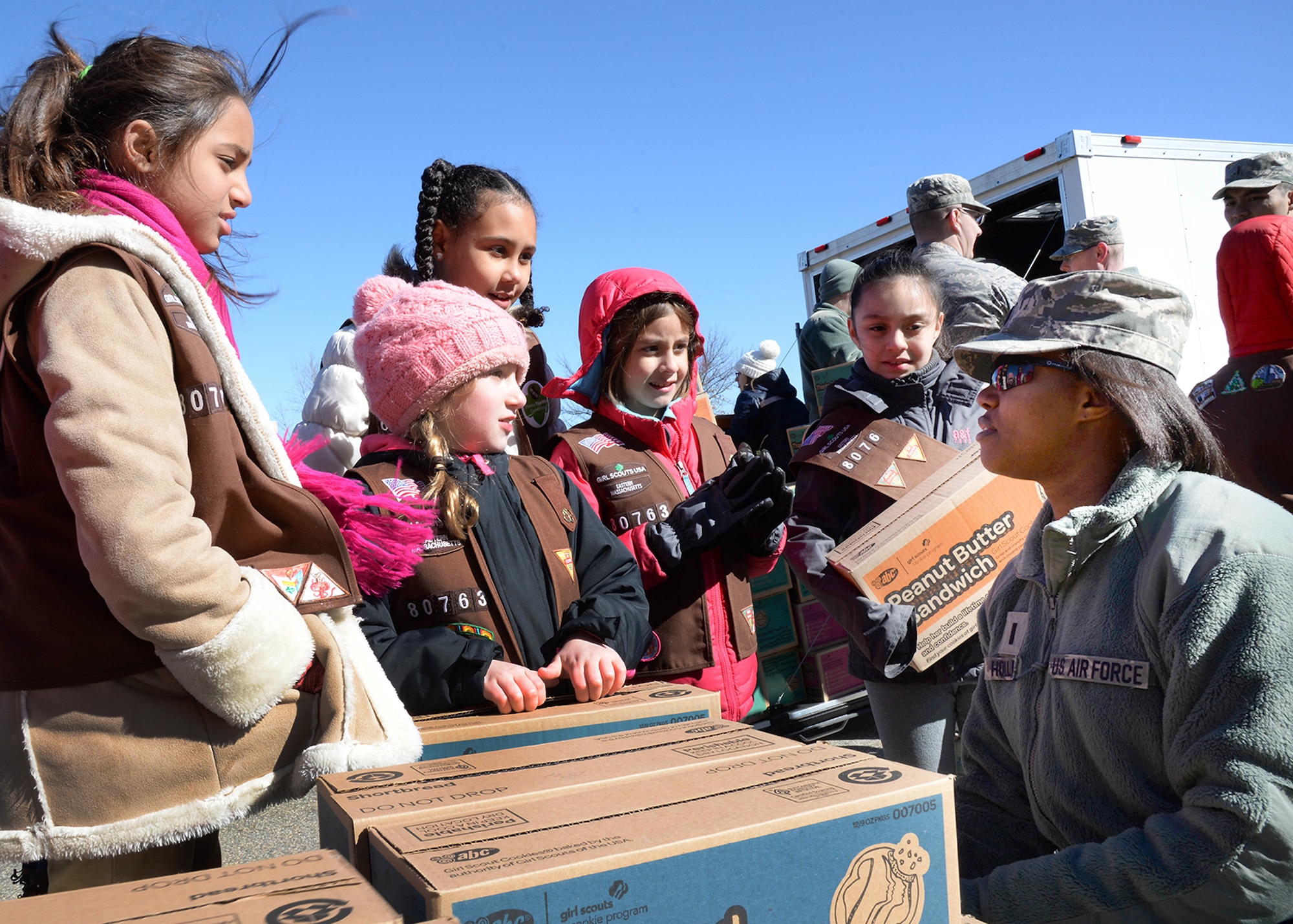 Girl Scouts from Brownie Troop 80763 in Brockton, Mass. gather around 1st Lt. Shaina Holler, 66th Force Support Squadron Military Personnel Section Deputy Chief, at Hanscom Air Force Base, Mass., March 19. Approximately 450 Girl Scouts and their families visited the base to donate boxes of Girl Scout cookies to military and veteran organizations as part of the Cookies for a Cause program. (U.S. Air Force photo by Linda LaBonte Britt)