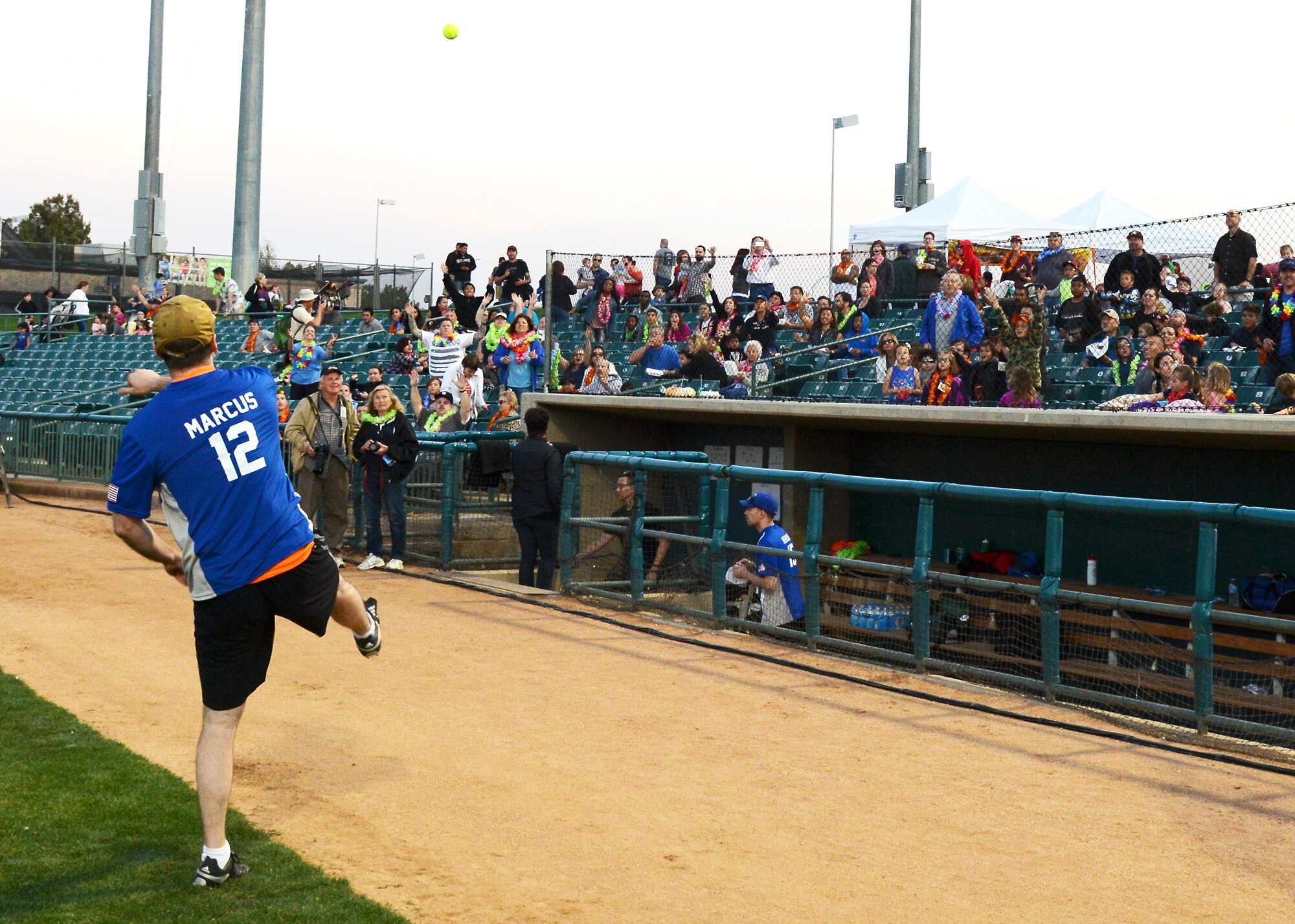 Capt. Gregory Marcus, U.S. Air Force Test Pilot School, tosses a softball signed by both TPS and Blue Angels players into the stands during a game break March 18 at The Hangar in Lancaster. (U.S. Air Force photo by Kenji Thuloweit)
