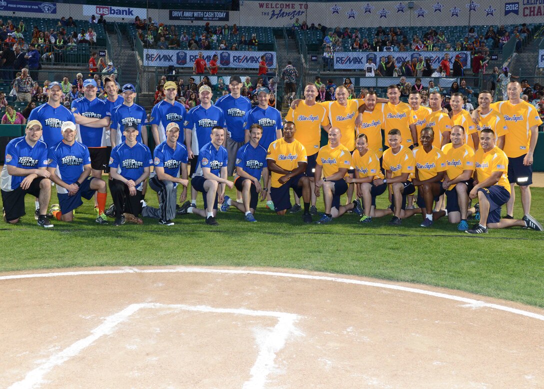 U.S. Air Force Test Pilot School students and staff in their blue jerseys pose for a group photo with members of the U.S. Navy Blue Angels team following a three inning softball game March 18. The USAF TPS team beat the Blue Angels 9-0 in the friendly game held at The Hangar in Lancaster. (U.S. Air Force photo by Kenji Thuloweit)
