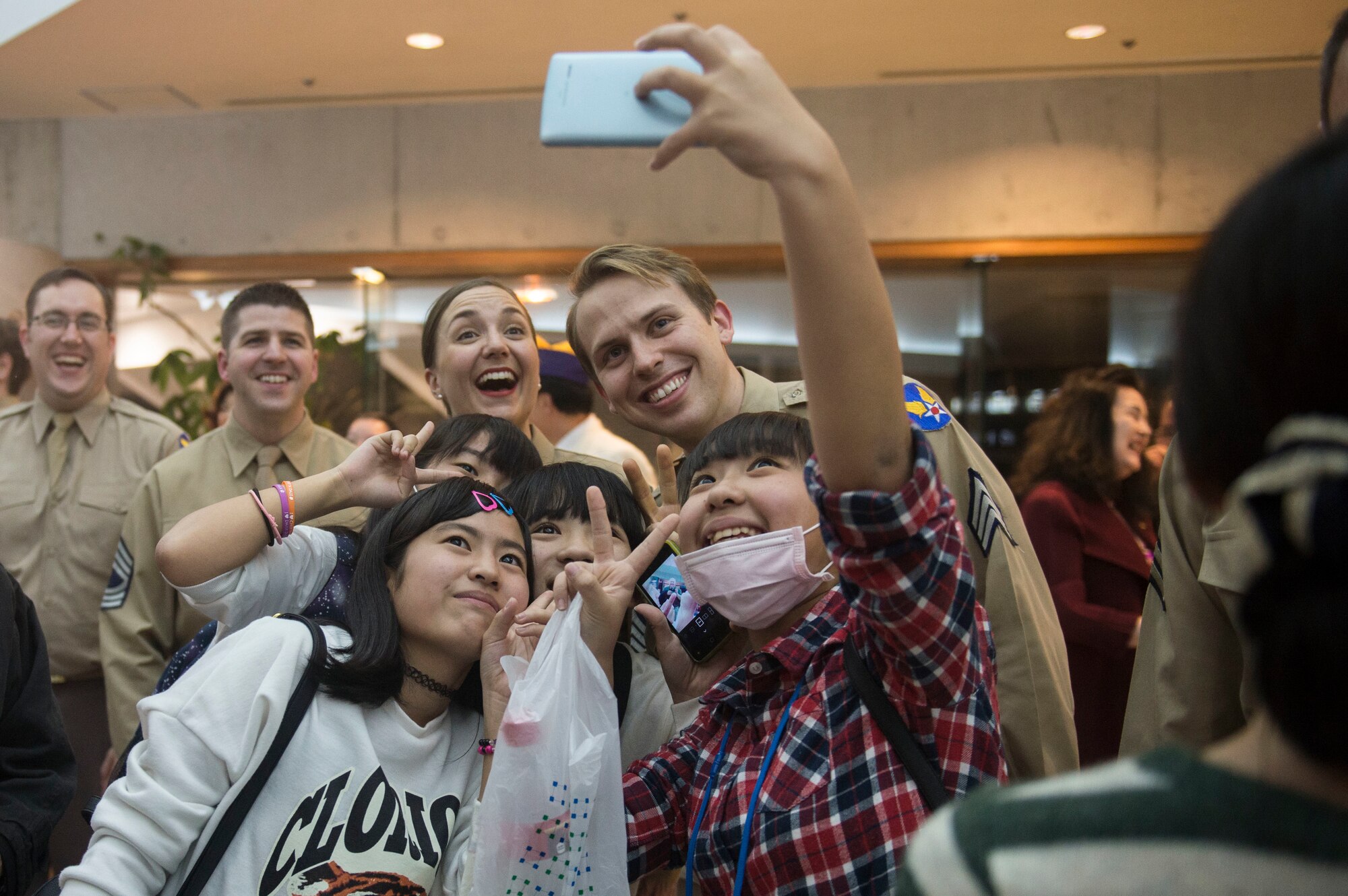 Okinawan teenagers take selfies with U.S. Air Force Band of the Pacific-Asia members March 14, 2016, after the show at the Pallet Civic Theater in Naha, Japan. The Pacific Showcase jazz ensemble thanked attendees for attending their performance. (U.S. Air Force photo by Senior Airman Omari Bernard)