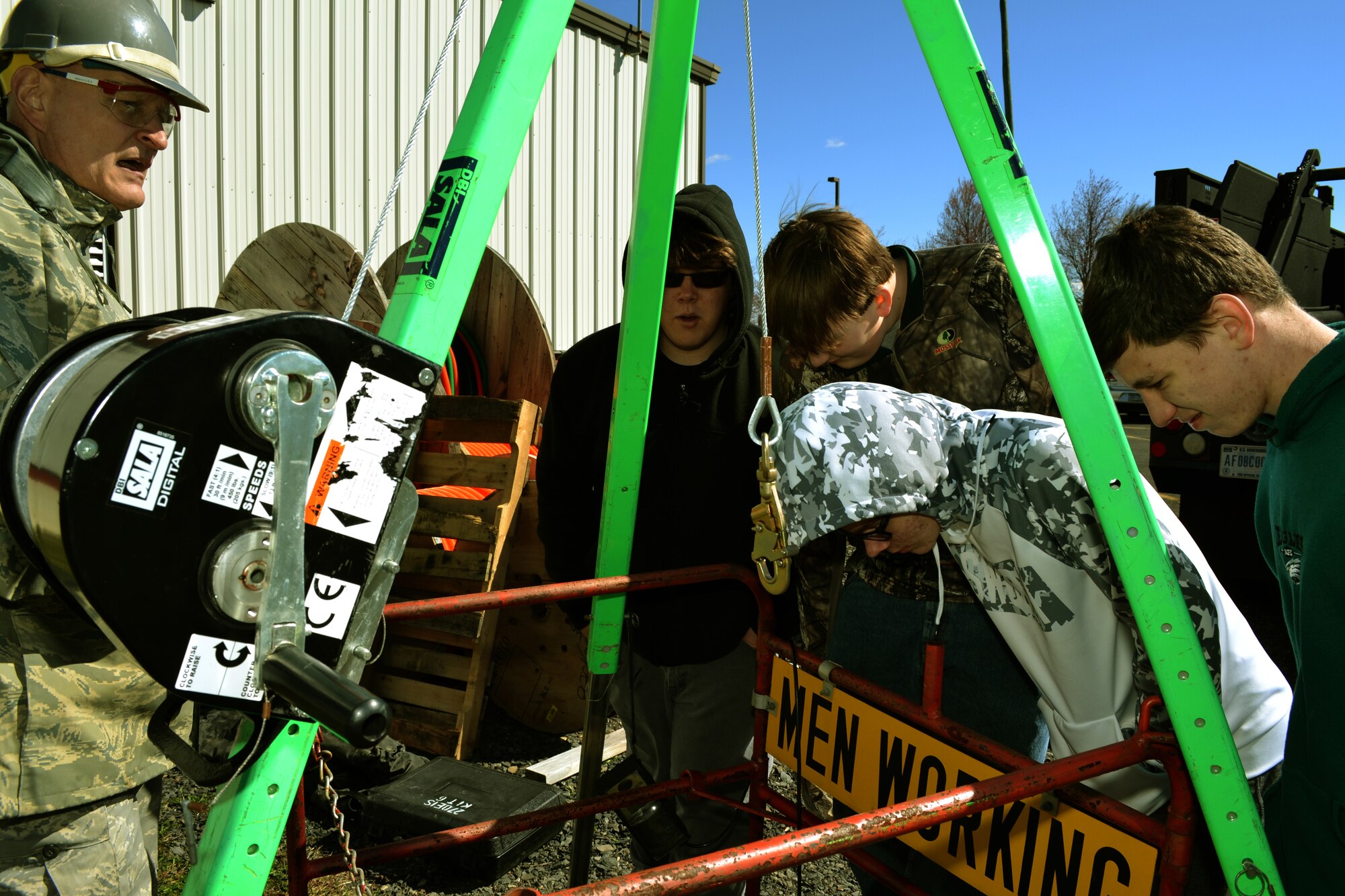 Staff Sgt. Frederick Becker, of the 270th Engineering Installation Squadron with the Pa. Air National Guard, explains safety procedures at permit-required confined spaces -- like a utility hole -- to a group of students from the Career Institute of Technology, Easton, Pa., during a school tour at Horsham Air Guard Station, Pa., March 18, 2016. The students were given a tour by the 111th Attack Wing recruiters throughout a RED HORSE, Det. 1 hangar and the 270th EIS. (U.S. Air National Guard photo by Tech. Sgt. Andria Allmond)