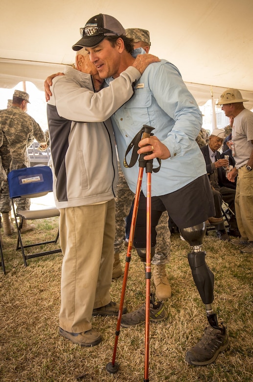 Harold Bologna, right, a former Navy special operations master chief, embraces Ben Skardon, a retired Army colonel and Bataan Death March Survivor, after they each walked more than eight miles in the Bataan Memorial Death March at White Sands Missile Range, N.M., March 20, 2016. Army photo by Staff Sgt. Ken Scar