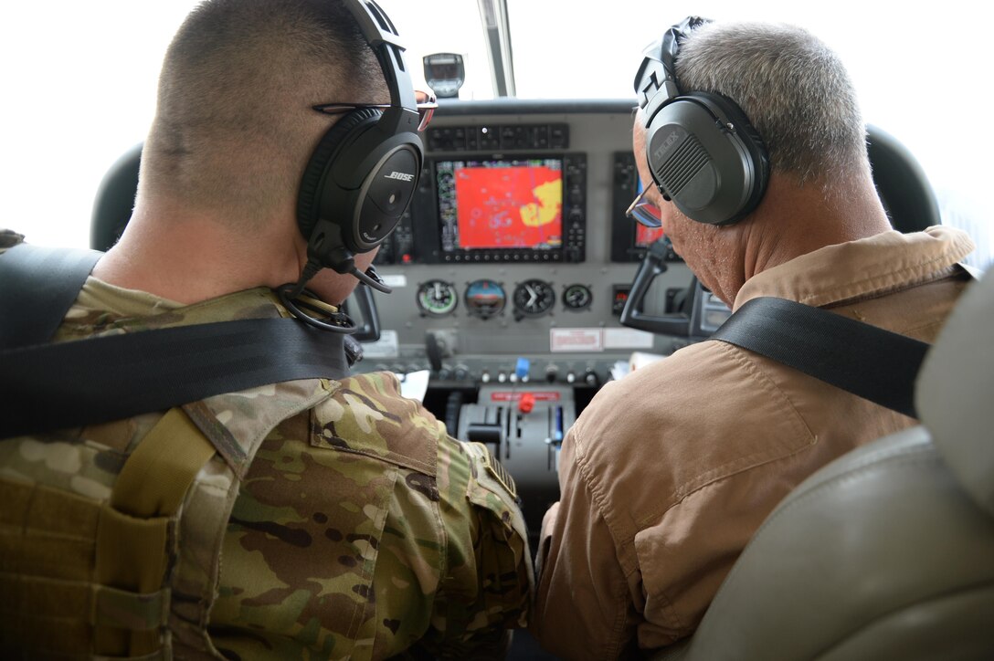 Maj. Carl Miller, Train, Advise, Assist Command-Air (TAAC-Air) instructor pilot, goes through pre-flight checklists with his Afghan Air Force counterpart on a training mission at Hamid Karzai International Airport, Kabul, Afghanistan, Sept. 21, 2015. The TAAC-Air mission is to train, advise and assist the AAF to be a capable, professional and sustainable air force. (U.S. Air Force photo by Staff Sgt. Sandra Welch/released)