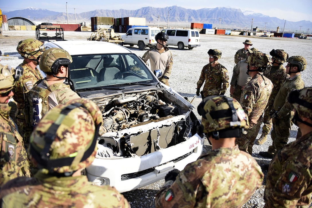 A U.S. airman, center, speaks with Italian soldiers during combined extrication training at Bagram Airfield, March 19, 2016.The airman is a pararescueman assigned to the 83rd Expeditionary Rescue Squadron. Air Force photo by Capt. Bryan Bouchard