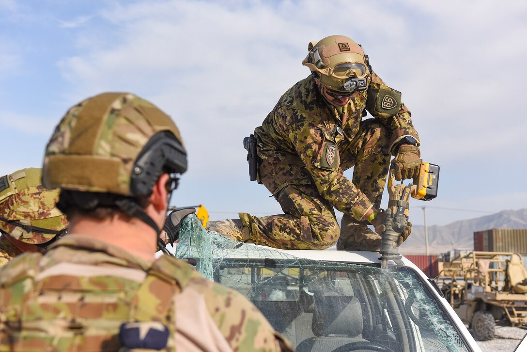 An Italian soldier uses a reciprocal saw to remove a vehicle’s windshield during combined extrication training with U.S. airmen at Bagram Airfield, Afghanistan, March 19, 2016. Air Force photo by Capt. Bryan Bouchard