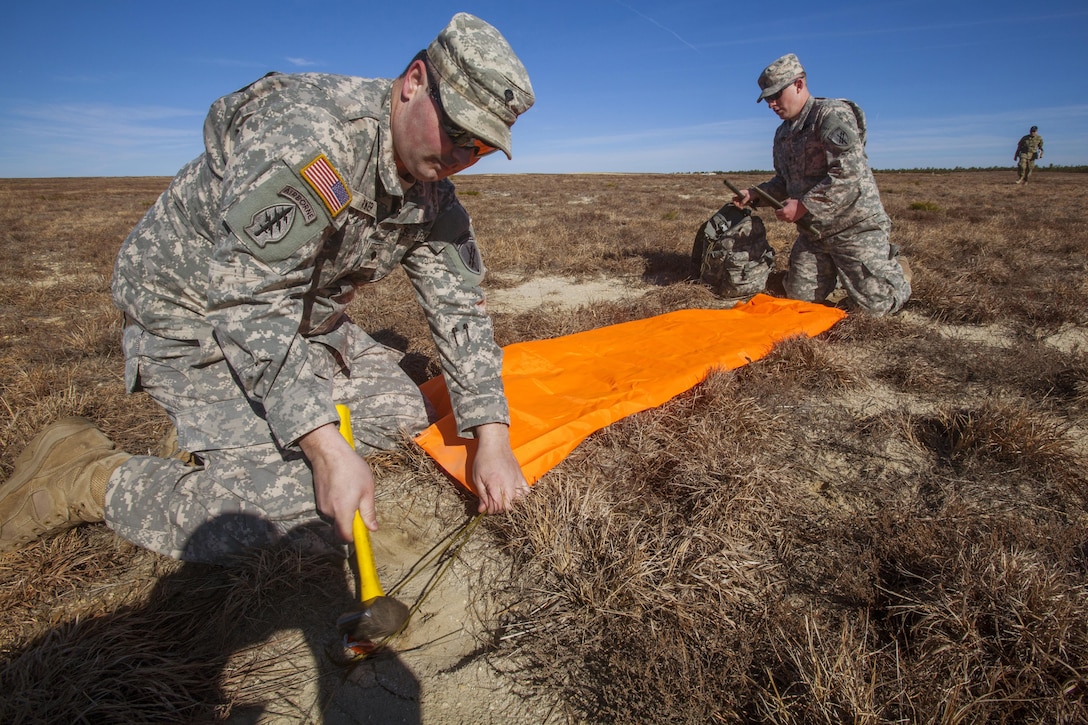 Soldiers position VS-17 marker panels to guide UH-60 Black Hawk helicopters during a joint training airborne operation at Coyle drop zone at Joint Base McGuire-Dix-Lakehurst, N.J., March 12, 2016. New Jersey Air National Guard photo by Master Sgt. Mark C. Olsen