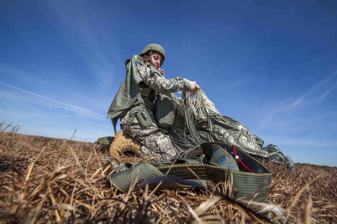 A soldier recovers her parachute after jumping from UH-60 Black Hawk helicopter during a joint training airborne operation at Coyle drop zone at Joint Base McGuire-Dix-Lakehurst, N.J., March 12, 2016. New Jersey Air National Guard photo by Master Sgt. Mark C. Olsen