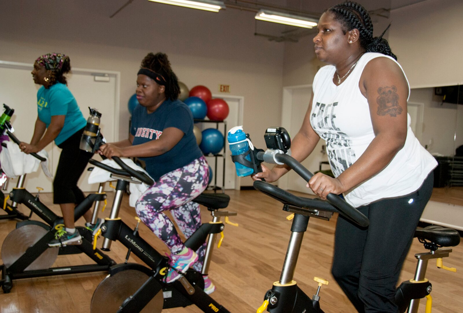 Ahawana Williams, Anita Elum-Mason and Ieshia Clark, all from DLA Installation Support, participate in a cycling class at the HQC Fitness Center. They are among more than 200 employees taking part in the 12-week Winter Warrior Challenge.