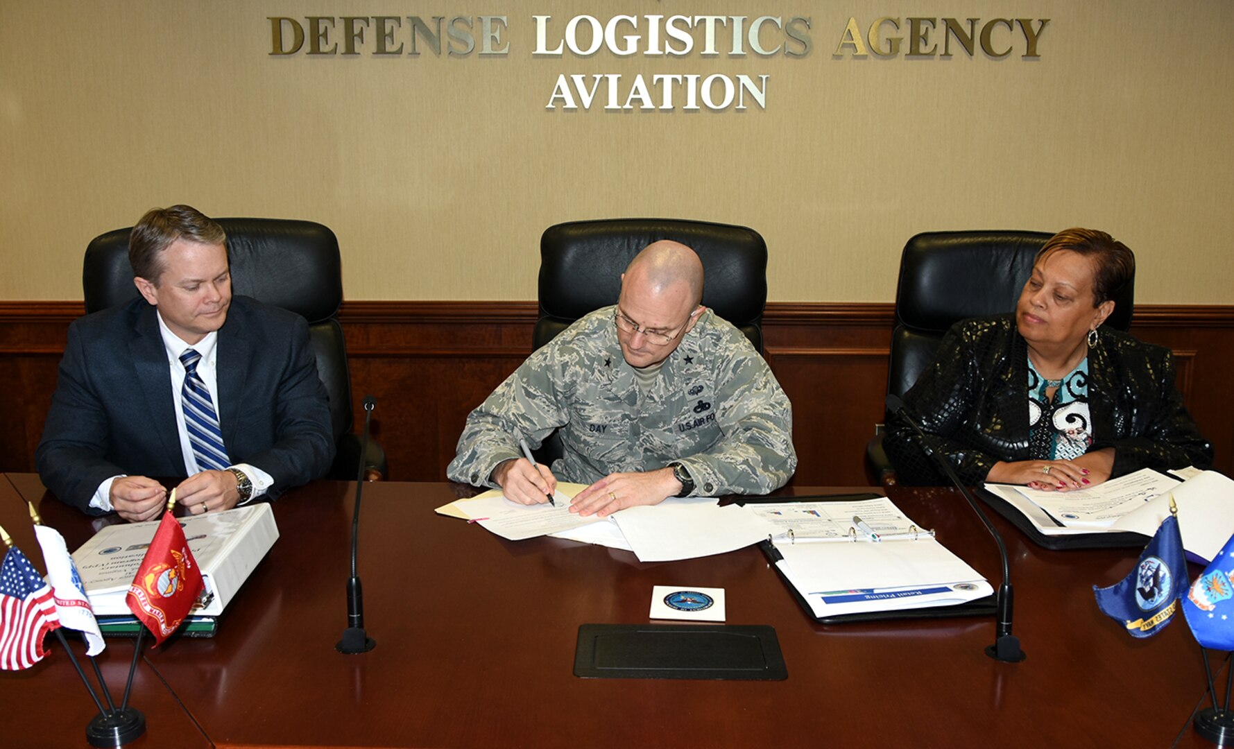 David Gibson, site director, Defense Logistics Agency Installation Support at Richmond and Lucy Lewis, president, American Federation of Government Employees Local 1992, look on as DLA Aviation Commander Air Force Brig. Gen. Allan Day signs the application March 15, 2016, requesting an Occupational Safety and Health Administration inspection to determine Defense Supply Center Richmond’s qualification for earning a star under OSHA’s Voluntary Protection Program. 
