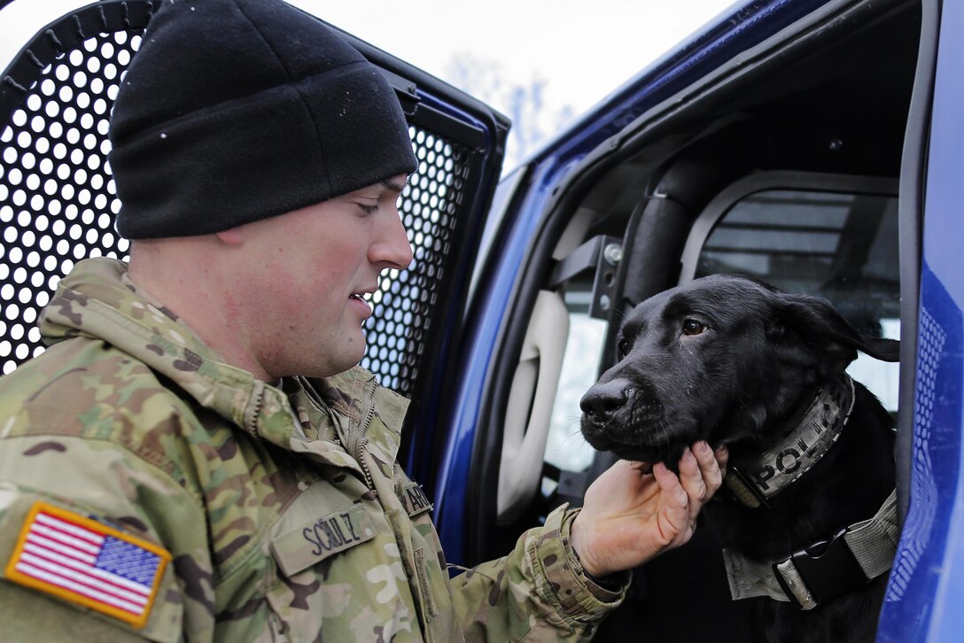 Army Spc. Jared Shultz interacts with Teddy, his military working dog, before participating in K-9 training at Joint Base Elmendorf-Richardson, Alaska, March 17, 2016. Shultz is a dog handler assigned to the 549th Military Working Dog Detachment. Air Force photo by Alejandro Pena