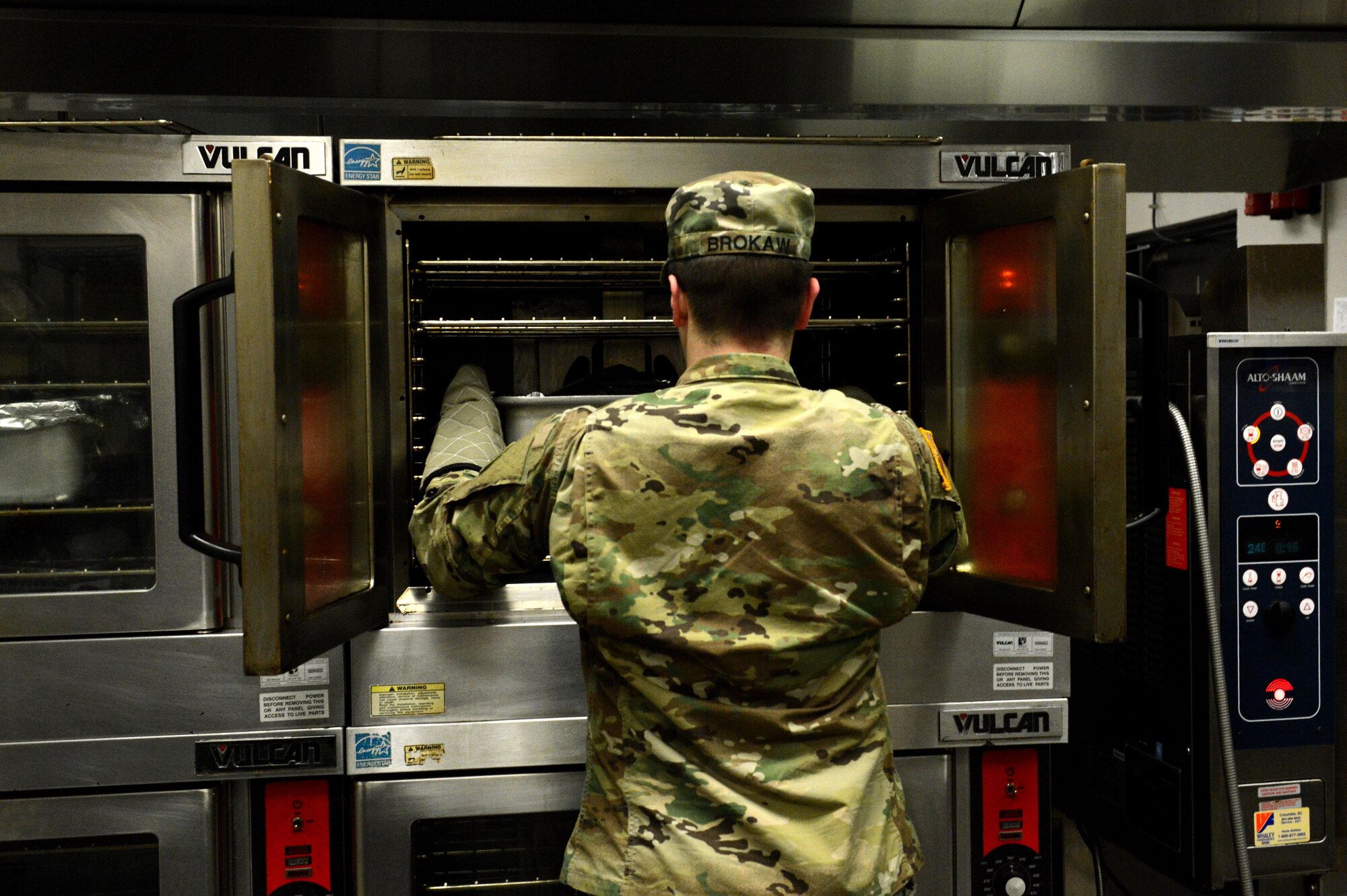 U.S. Army Pfc. Matthew Brokaw, U.S. Army Central Command culinary specialist, places a beef brisket into an oven at Shaw Air Force Base, S.C., March 17, 2016. The Chief Master Sgt. Emerson E. Williams Dining Facility staff spend close to three hours every day preparing lunch. (U.S. Air Force photo by Airman 1st Class Destinee Dougherty)