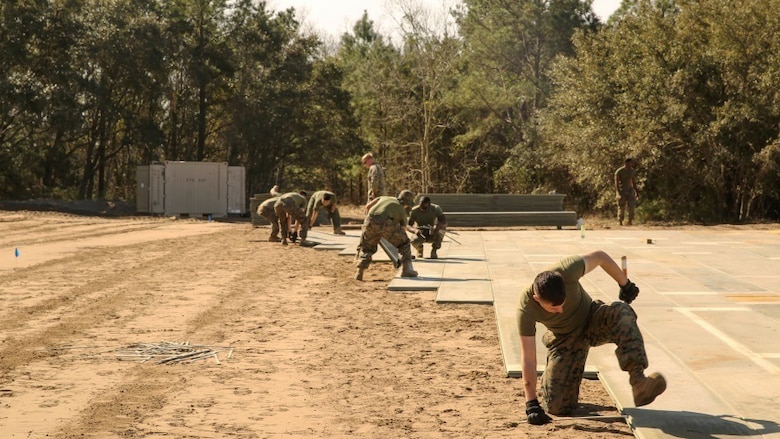 U.S. Marines with Marine Wing Support Squadron 272 construct a vertical take-off and landing pad during a Marine Corps Combat Readiness Evaluation at Marine Corps Auxiliary Landing Field Bogue, North Carolina, March 17, 2016. The MCCRE, which went from March 14-18, tested MWSS-272’s ability to build an AM-2 aluminum matting V/TOL pad ready to accept incoming aircraft. MWSS-272 is part of Marine Aircraft Group 26, 2nd Marine Aircraft Wing.