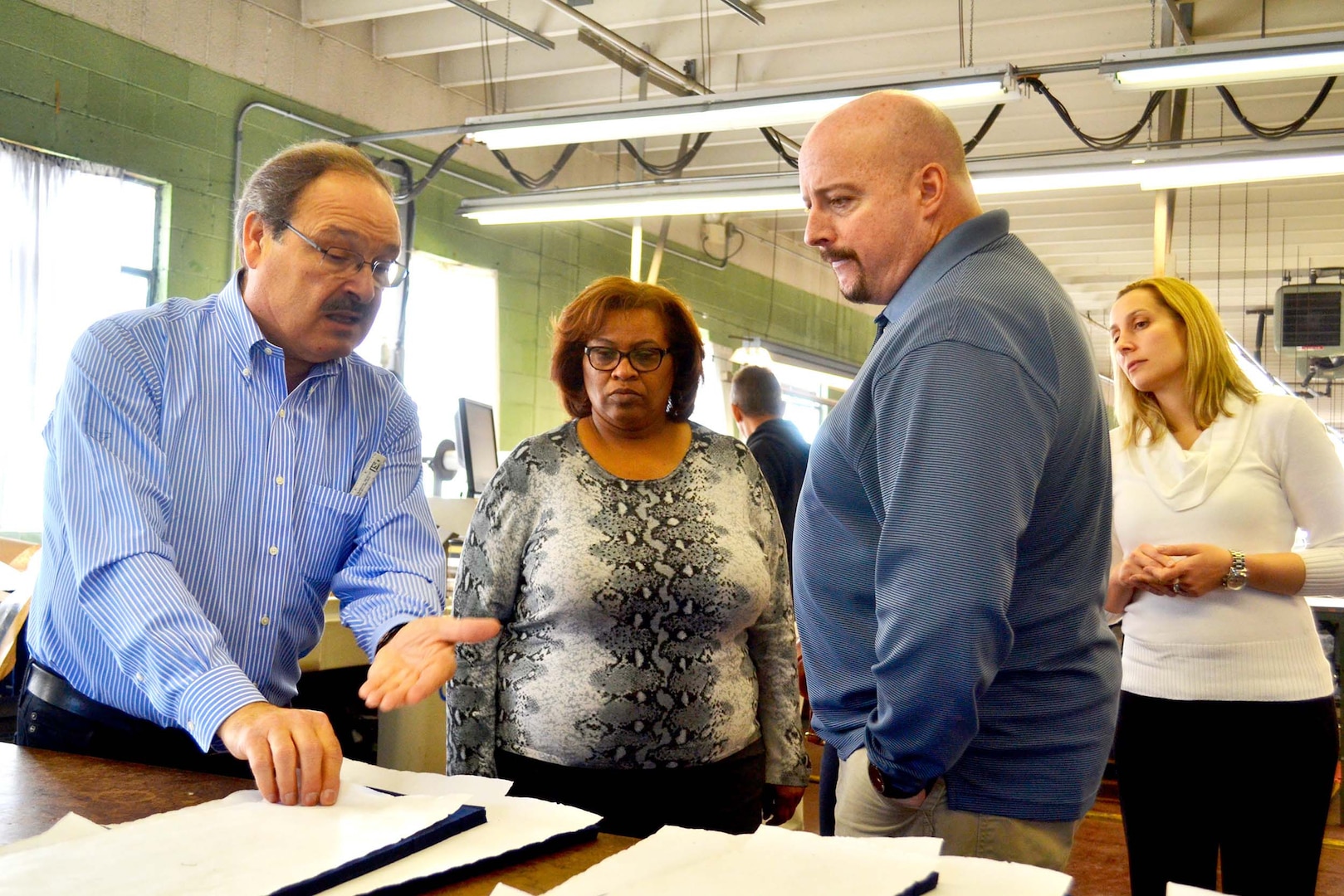 Alessandro Marcozzi, a manager at DeRossi & Son in Vineland, New Jersey, explains the clothing manufacturing process to Defense Logistics Agency Troop Support employees Robin-Kirkland Gonzalez, customer account specialist, Ken Drexinger, demand planner, and Jessica De La Hoz, contracting officer, all with the Clothing and Textiles supply chain during a visit to plant March 2.