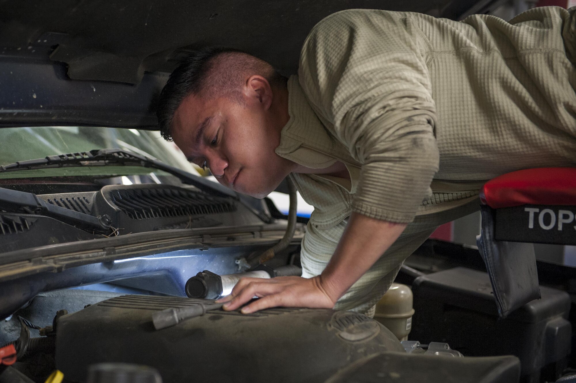 U.S. Air Force Airman 1st Class Ryan Abella, 23d Logistics Readiness Squadron vehicle maintenance apprentice, pulls a spark plug wire out of a government operated vehicle, March 22, 2016, at Moody Air Force Base, Ga. The vehicle management flight is comprised of the customer service section, vehicle management and analysis, multipurpose maintenance, fire truck maintenance, refueling maintenance and material control shops. (U.S. Air Force photo by Airman 1st Class Lauren M. Johnson/Released)