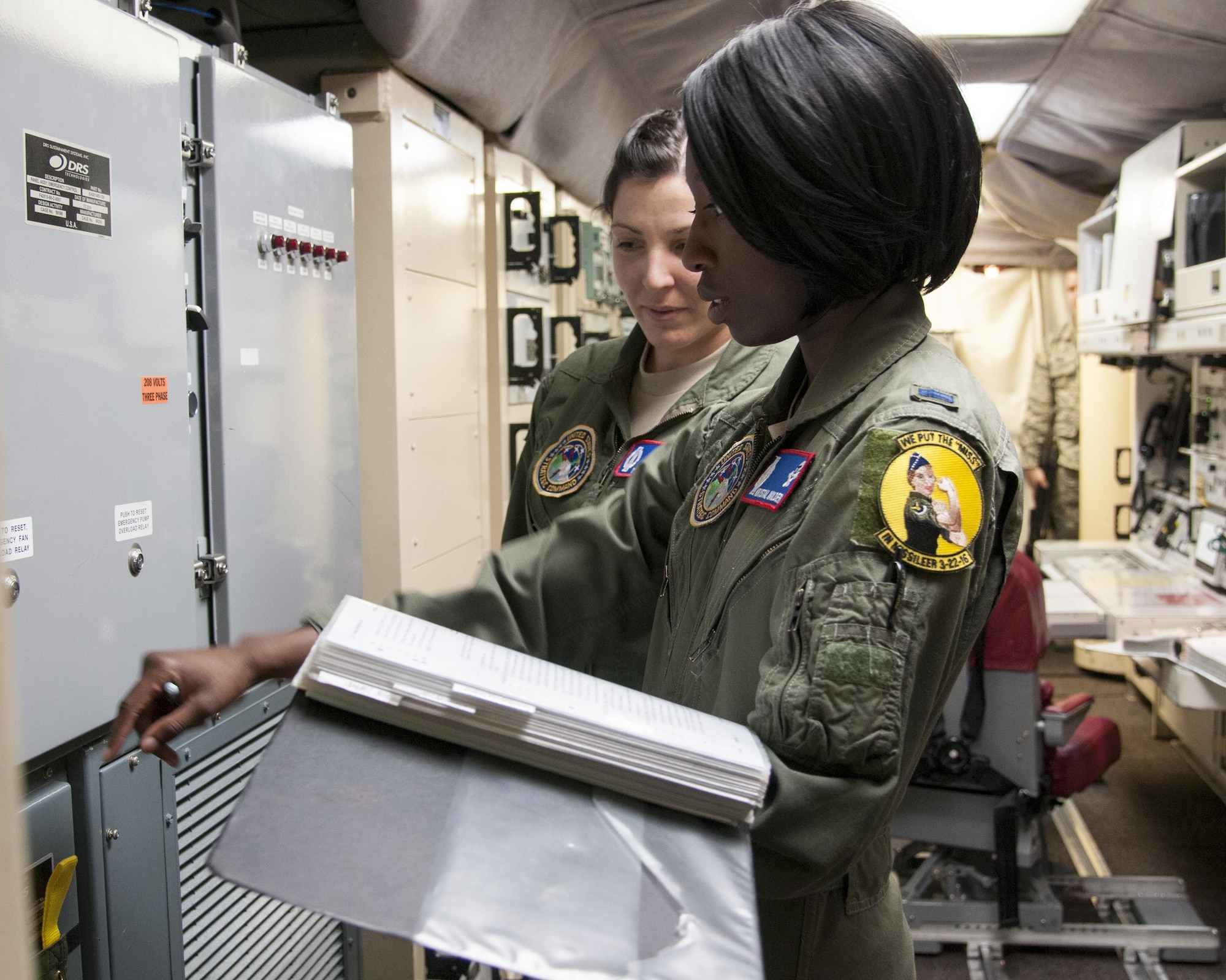 1st Lt. Krystal Wilder, 319th Missile Squadron combat crew deputy, reviews a checklist with 1st Lt. Mary Vasta, 319th MS combat crew commander, in a launch control center, March 22, 2016, in the F.E. Warren Air Force Base, Wyo., missile complex. In 1978, the first alert pulled by a female officer was conducted with the Titan II missile system. (U.S. Air Force photo by Airmen 1st Class Malcolm Mayfield)