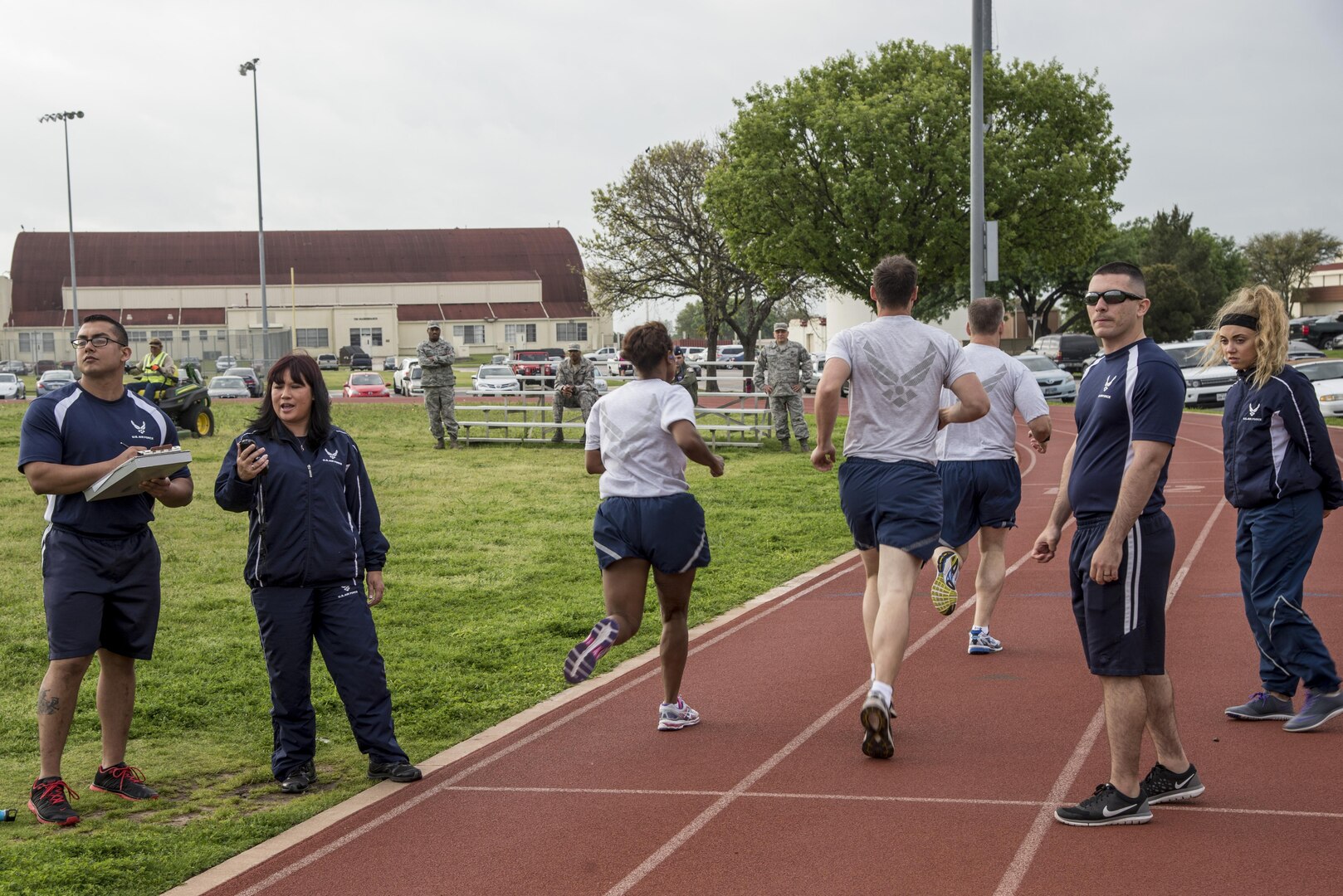 Staff Sgt. Isajas De Leon, 902nd Security Forces Squadron patrolman and 502nd Force Support Squadron Fitness Assessment Cell augmentee, Kim Rennart, 502nd FSS FAC lead, Airman 1st Class Justin Cook, 902nd SFS patrolman and 502nd FSS FAC augmentee, and Airman 1st Class Bianca Osborn,359th Medical Operations Squadron pediatric aerospace medical technician and 502nd FSS FAC augmentee, assess runners during their Air Force physical fitness test. Augmentees take a two and a half day course and spend 45-90 days working as part of the FAC.