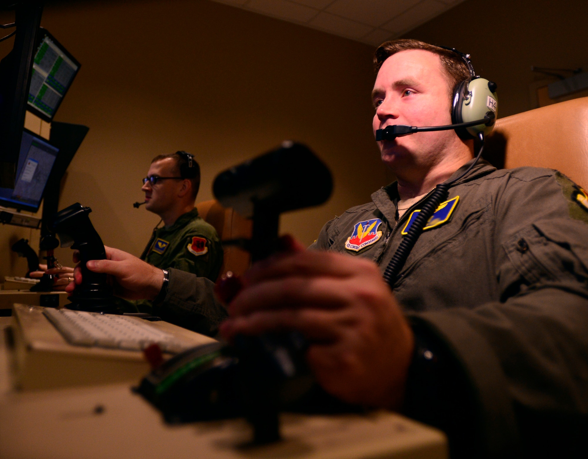 Capt. Jonathan, 432nd Wing pilot, right, and Staff Sgt. Matthew, 432nd WG sensor operator, left, fly a training mission Oct. 13, 2015, at Creech Air Force Base, Nevada. The 432nd Wing conducted 189 weapon strikes in July of 2015 and 249 in August, setting a record for the number of strikes in a month in support of Operation Inherent Resolve. (U.S. Air Force photo by Airman 1st Class Christian Clausen/released)