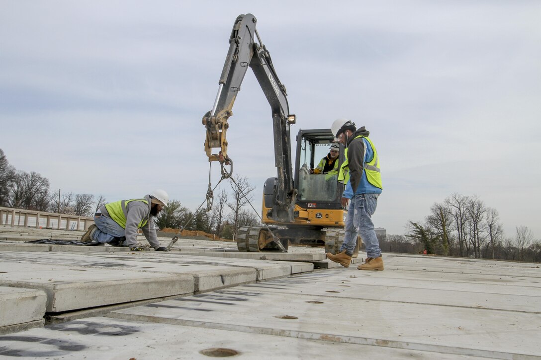 ARLINGTON, Va.  – Contractors working at the Arlington National Cemetery’s Millennium Project remove the top off a pre-cast, pre-placed double-depth-concrete liner so identification numbers can be painted in it, March 22, 2016. The liners are a first for the cemetery and will maximize burial opportunities within the 27 acre expansion project. (U.S. Army photo/Patrick Bloodgood)