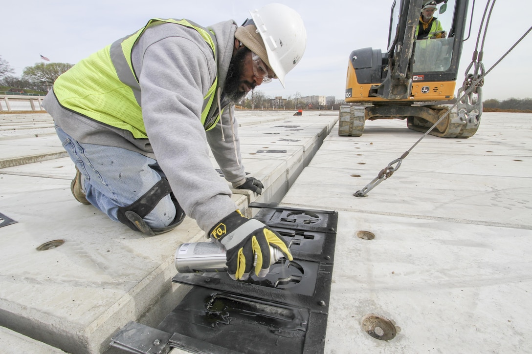 ARLINGTON, Va. – Darian Moon, a contractor working on the Arlington National Cemetery’s Millennium Project paints identification numbers on the top off a pre-cast, pre-placed double-depth-concrete liner, March 22, 2016. The liners are a first for the cemetery and will maximize burial opportunities within the 27 acre expansion project. (U.S. Army photo/Patrick Bloodgood)