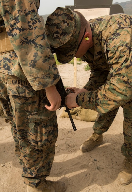 Staff Sgt. Brandon Gilbow adjusts Lance Cpl. Bryan Garlitz’ Advanced Target Pointer/ Illuminator/ Aiming Laser before conducting rifle qualification at Camp Pendleton March 3, 2016. Marines with 1st Law Enforcement Battalion performed a five-day offensive training evolution in an effort to better integrate military police officers with infantry units. Gilbow, a native of Baltimore, is a correctional specialist and Garlitz, a native of Morrisville, Pa., is an armory custodian with Company B, 1st LE Bn., I Marine Expeditionary Force. (U.S. Marine Corps photo by Lance Cpl. Justin E. Bowles/Released)