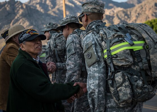 Valdemar DeHerrera, a Bataan Survivor, shakes hands of participants during the commencement of the Bataan Memorial Death March at White Sands Missile Range N.M., March 20. Over 6,000 participants came to honor more than 76,000 Prisoners of War and Missing in Action from Bataan and Corregidor during World War II. The 26.2-mile course starts on WSMR, enters hilly terrain and finishes through sandy desert trails, with elevation ranging from 4,100 to 5,300 feet. (U.S. Air Force photo by Senior Airman Chase Cannon)