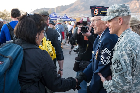 Chief Master Sgt. Ret. Harold Bergbower shakes hands of participants during the commencement of the Bataan Memorial Death March at White Sands Missile Range N.M., March 20. Over 6,000 participants came to honor more than 76,000 Prisoners of War and Missing in Action from Bataan and Corregidor during World War II. The 26.2-mile course starts on WSMR, enters hilly terrain and finishes through sandy desert trails, with elevation ranging from 4,100 to 5,300 feet. (U.S. Air Force photo by Senior Airman Chase Cannon)