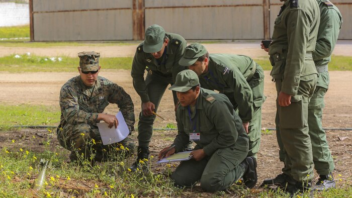 U.S. Marine Staff Sgt. Phil Mayer, and explosive ordnance disposal technician with Special-Purpose Marine Air-Ground Task Force Crisis Response-Africa, listens to Moroccan soldiers as they conduct ordnance reconnaissance on an inert mortar during a training exercise in Kenitra, Morocco, March 15, 2016. Students from across the Moroccan military branches are working together with U.S. Marine and Utah Air National Guard explosive ordnance disposal technicians and Utah National Guard engineers to build up Morocco’s demining capabilities. The training is part of the U.S. Humanitarian Mine Action Program which has been assisting partner nations in developing their mine action capacity since 1988.
