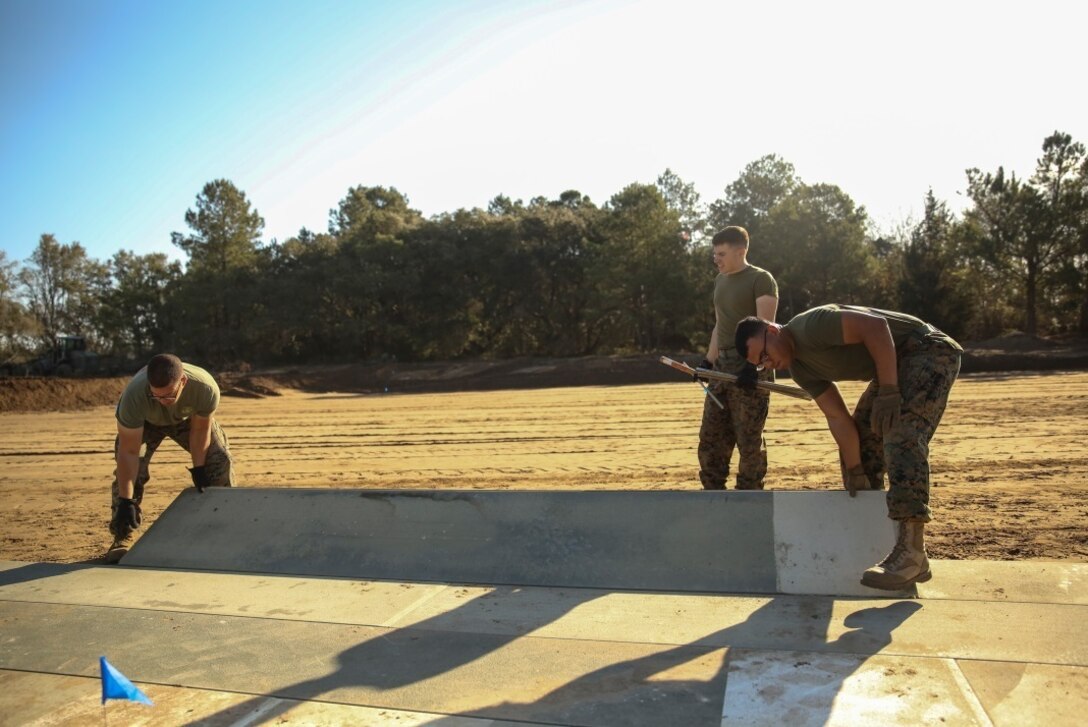 U.S. Marines with Marine Wing Support Squadron 272 construct a vertical take-off and landing pad during a Marine Corps Combat Readiness Evaluation at Marine Corps Auxiliary Landing Field Bogue, N.C., March 17, 2016. The MCCRE, which went from March 14-18, tested MWSS-272’s ability to build an AM-2 aluminum matting V/TOL pad ready to accept incoming aircraft. MWSS-272 is part of Marine Aircraft Group 26, 2nd Marine Aircraft Wing.(U.S. Marine Corps photo by Cpl. Kaitlyn V. Klein/Released)