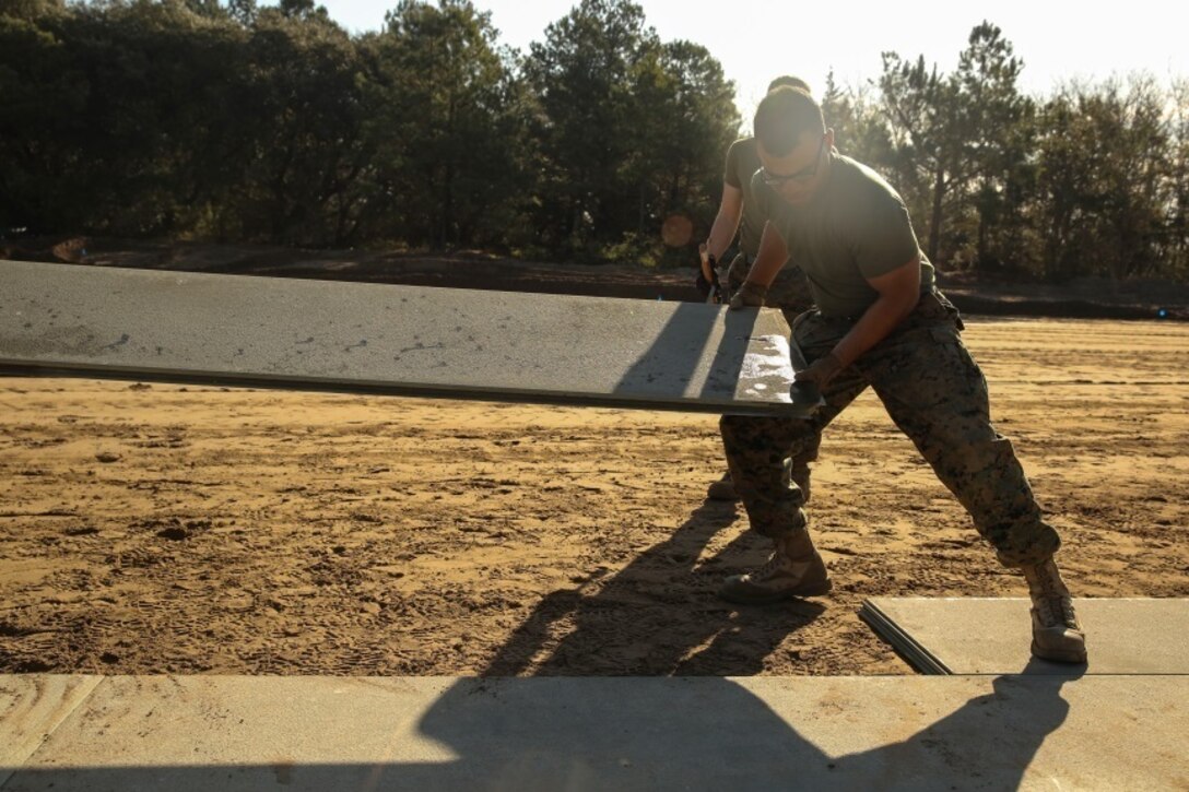 U.S. Marines with Marine Wing Support Squadron 272 construct a vertical take-off and landing pad during a Marine Corps Combat Readiness Evaluation at Marine Corps Auxiliary Landing Field Bogue, N.C., March 17, 2016. The MCCRE, which went from March 14-18, tested MWSS-272’s ability to build an AM-2 aluminum matting V/TOL pad ready to accept incoming aircraft. MWSS-272 is part of Marine Aircraft Group 26, 2nd Marine Aircraft Wing. (U.S. Marine Corps photo by Cpl. Kaitlyn V. Klein/Released)
