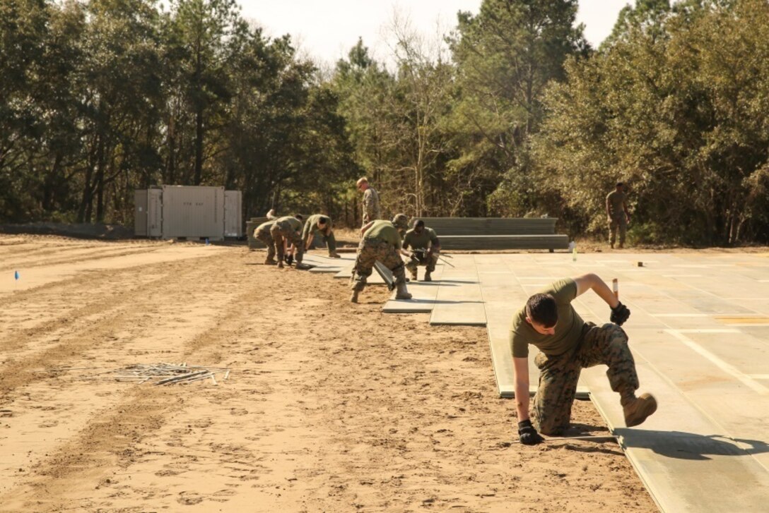 U.S. Marines with Marine Wing Support Squadron 272 construct a vertical take-off and landing pad during a Marine Corps Combat Readiness Evaluation at Marine Corps Auxiliary Landing Field Bogue, N.C., March 17, 2016. The MCCRE, which went from March 14-18, tested MWSS-272’s ability to build an AM-2 aluminum matting V/TOL pad ready to accept incoming aircraft. MWSS-272 is part of Marine Aircraft Group 26, 2nd Marine Aircraft Wing. (U.S. Marine Corps photo by Cpl. Kaitlyn V. Klein/Released)