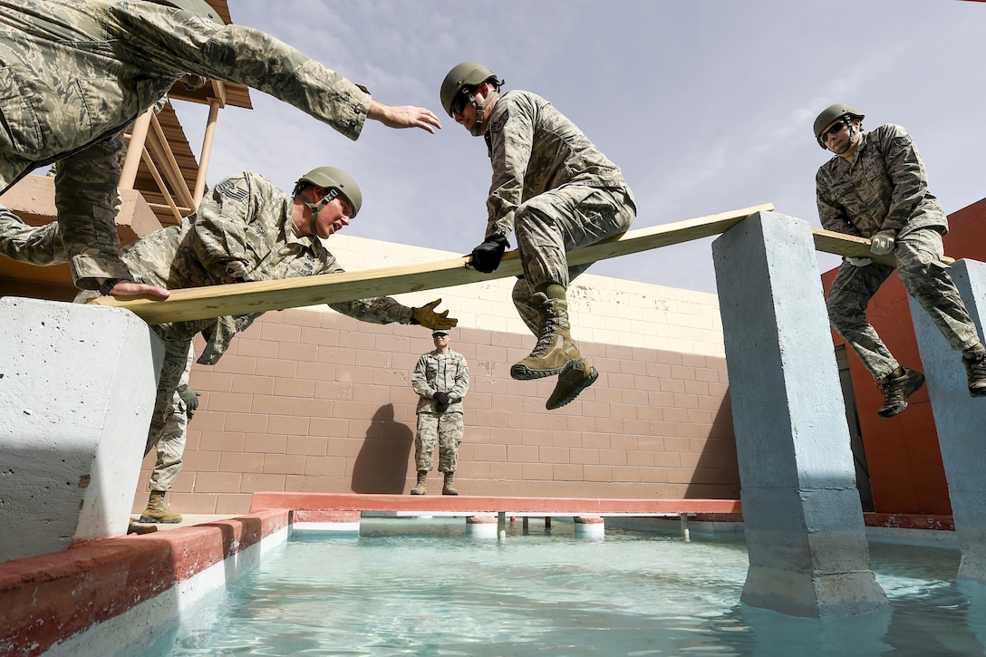 Airmen participating in Operational Contract Support Joint Exercise 2016 work together to cross an obstacle at Fort Bliss, Texas, March 22, 2016. Air Force photo by Staff Sgt. Jonathan Snyder