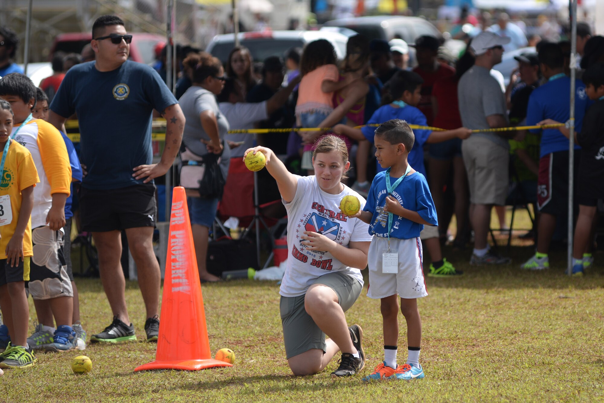 Airman Chealsey Miller, 36th Munitions Squadron conventional maintenance crew member, demonstrates to an athlete how to throw a ball during the 2016 Special Olympics Guam Track and Field Competition March 19, 2016, at Okkodo High School in Dededo, Guam. Military service members volunteered as coaches, event facilitators and other roles in the annual Special Olympics Guam events. (U.S. Air Force photo/Airman 1st Class Jacob Skovo)
