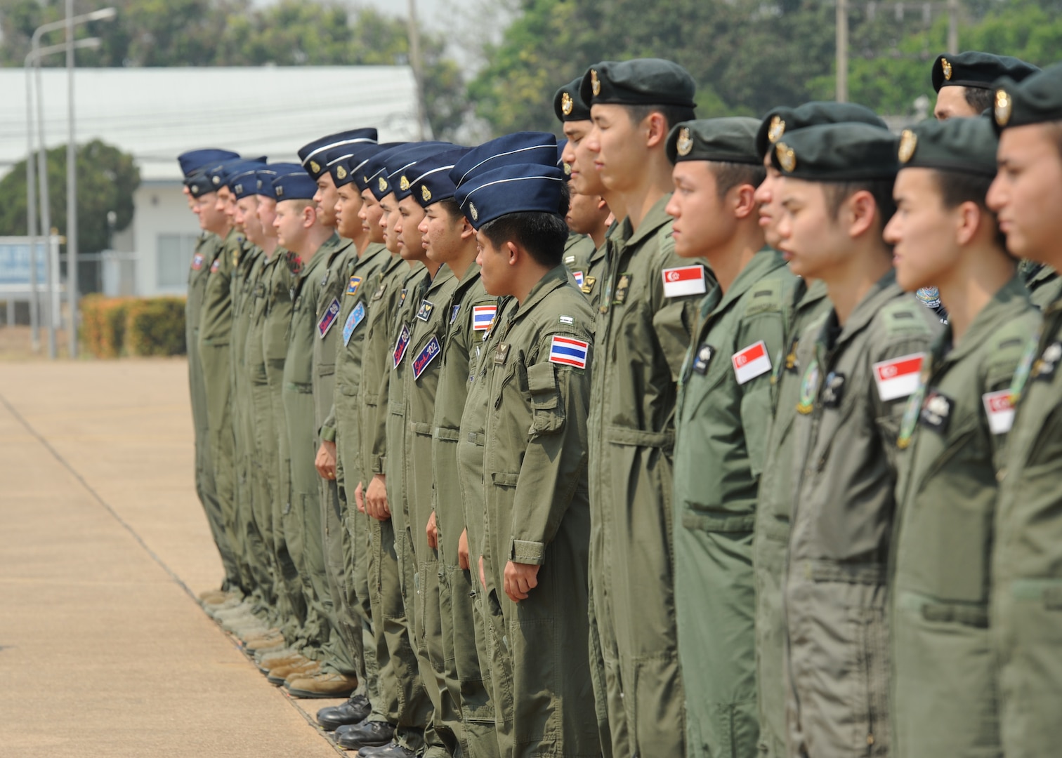 Pilots from the Republic of Singapore Air Force, the Royal Thai Air Force, and the U.S. Air Force stand in formation during the closing ceremony of Exercise Cope Tiger 16 on Korat Royal Thai Air Force Base, Thailand, March 18, 2016. The multilateral exercise involved a combined total of 87 aircraft that completed 1,003 sorts of a two week period. Exercise Cope Tiger 16 included over 1,200 personnel from three countries and continues the growth of strong, interoperable and beneficial relationships within the Asia-Pacific Region, while demonstrating U.S. capability to project forces strategically in a combined, joint environment. (U.S. Air Force Photo by Tech Sgt. Aaron Oelrich/Released)