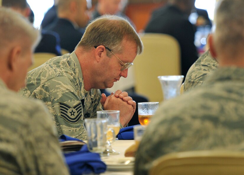 Members of Joint Base Charleston join Father Gildardo Garcia in prayer for Department of Defense civilians during the National Prayer Luncheon, March 17, 2016 at the Charleston Club. The event included several different prayers and readings from the Tanakh, Qur’an and New Testament.