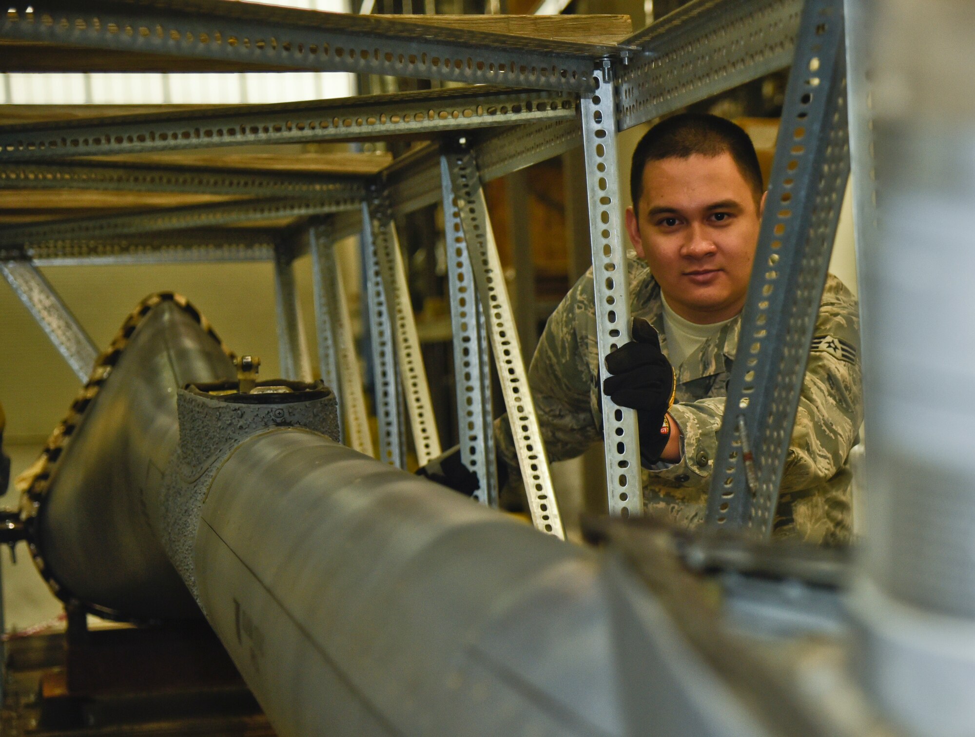 Senior Airman Johnraphael Navarro, 92nd Logistics Readiness Squadron traffic management journeyman, pushes a boom from a KC-135 Stratotanker March 22, 2016, at Fairchild Air Force Base, Wash. The boom will be sent out by the Traffic Management Office to a new base for repairs. TMO will receive parts ranging from a small bolt to larger items like aircraft engines that have been ordered by an office on base. They will also receive assets from Supply that need to be shipped out, sometimes having to build crates to ship them in. (U.S Air Force photo/Airman 1st Class Taylor Bourgeous)