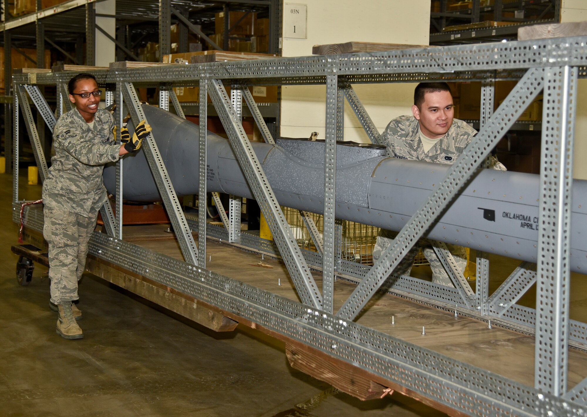 Airman 1st Class Patrice Simons, 92nd Logistics Readiness Squadron traffic management apprentice, assists Senior Airman Johnraphael Navarro, 92nd LRS traffic management journeyman, in moving a boom from a KC-135 Stratotanker March 22, 2016, at Fairchild Air Force Base, Wash. The boom will be sent out by the Traffic Management Office to a new base for repairs. TMO will receive parts ranging from a small bolt to larger items like aircraft engines that have been ordered by an office on base. They will also receive assets from Supply that need to be shipped out, sometimes having to build crates to ship them in. (U.S Air Force photo/Airman 1st Class Taylor Bourgeous)