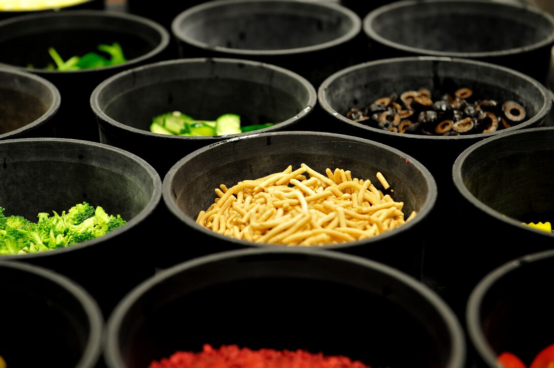 Salad toppings are offered to the Advanced Individual Training (AIT) students during lunch and dinner at the Resolute Dining Facility at Fort Eustis, Va., March 18, 2016. Pre-made salads prepared in shaker cups, and a bar designated for healthy food options are also offered as a better alternatives for the AIT students.  (U.S. Air Force photo by Airman 1st Class Breonna Veal)