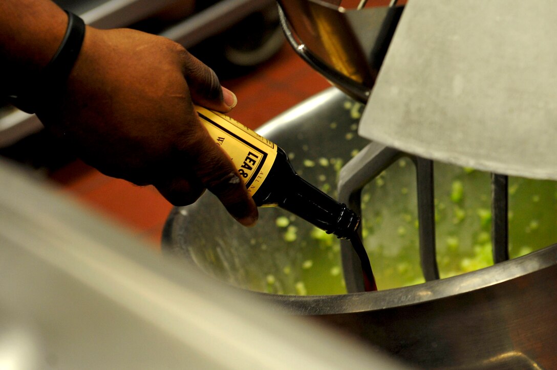 U.S. Army Sgt. 1st Class Carlos Smith, Resolute Dining Facility manager, pours Worcestershire sauce into a food mixer at Fort Eustis, Va., March 18, 2016. Advanced Individual Training students are encouraged to leave meal suggestions, which Smith and his staff try to accommodate when feasible.  (U.S. Air Force photo by Airman 1st Class Breonna Veal)