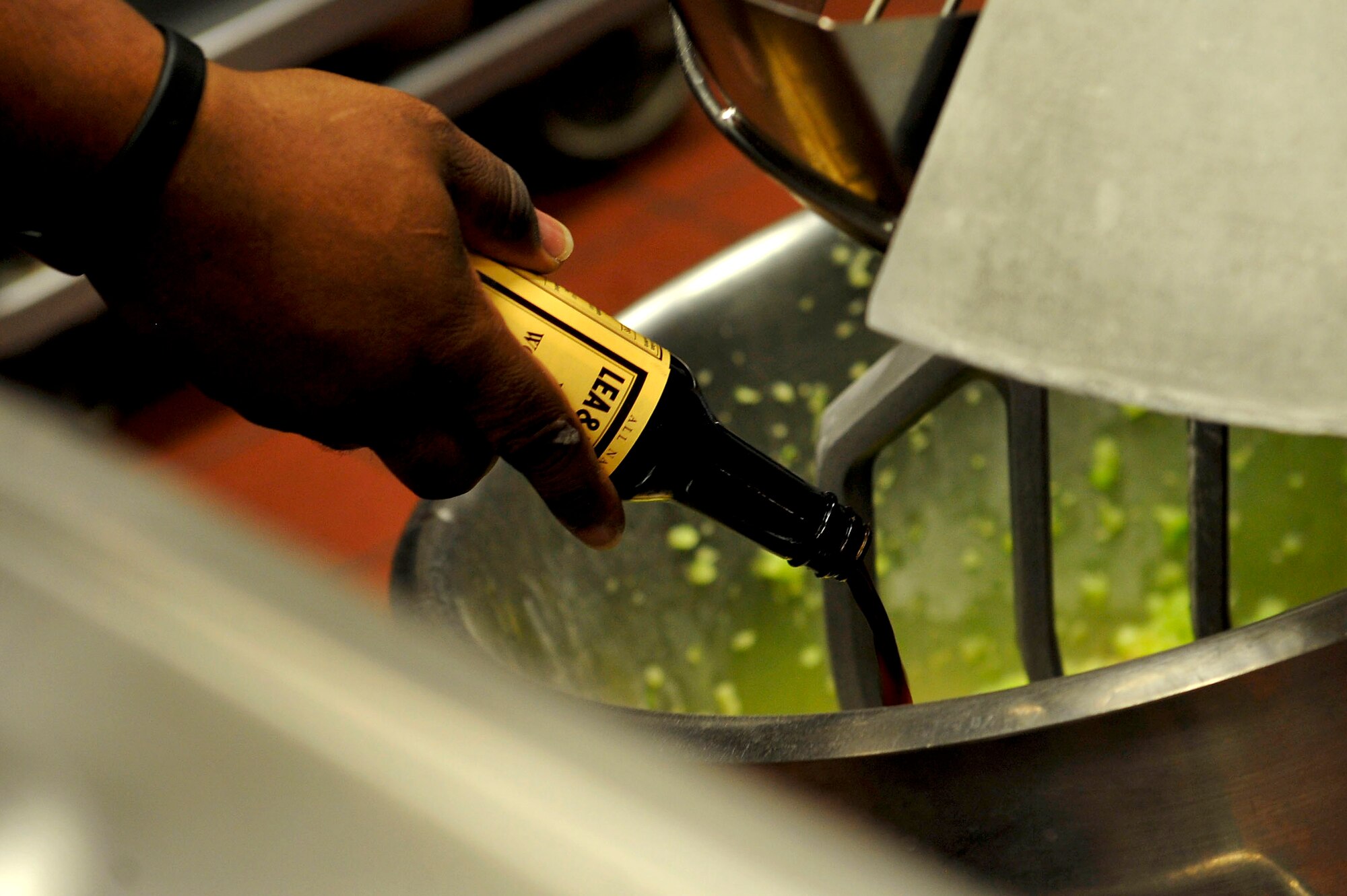 U.S. Army Sgt. 1st Class Carlos Smith, Resolute Dining Facility manager, pours Worcestershire sauce into a food mixer at Fort Eustis, Va., March 18, 2016. Advanced Individual Training students are encouraged to leave meal suggestions, which Smith and his staff try to accommodate when feasible.  (U.S. Air Force photo by Airman 1st Class Breonna Veal)