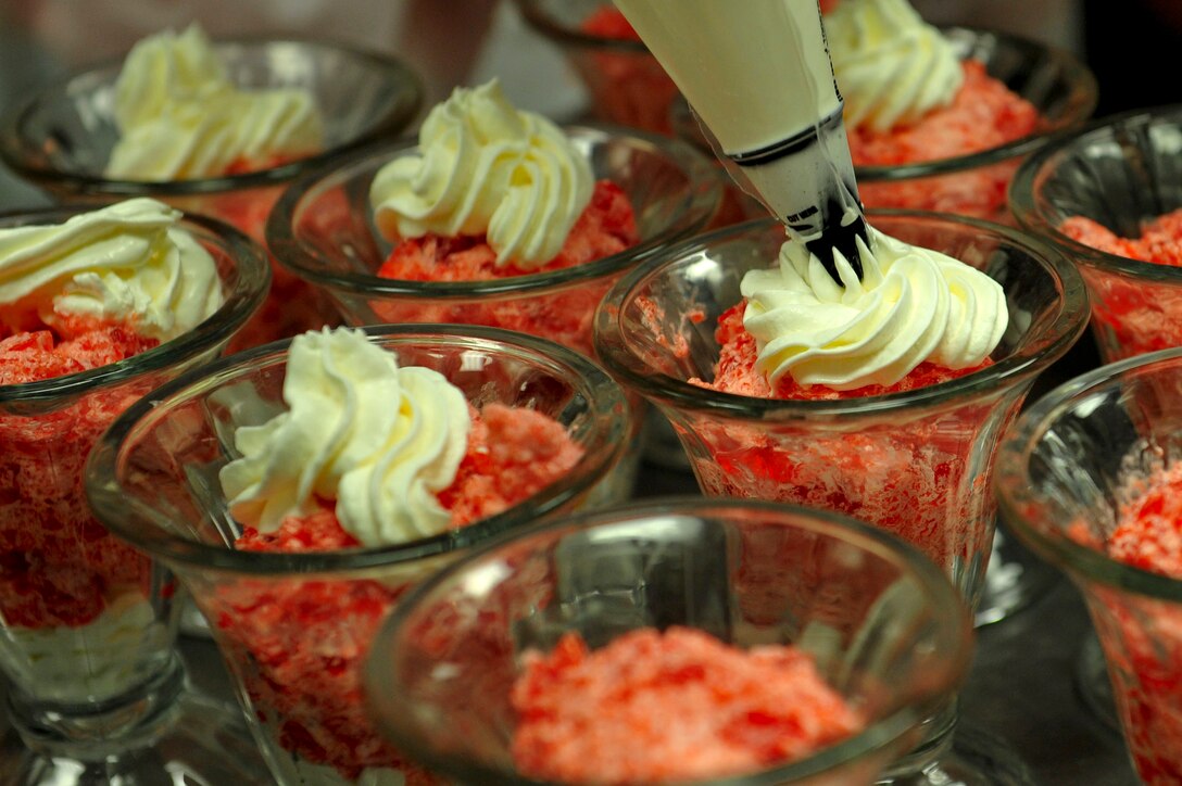 Glenda Davis, Resolute Dining Facility culinary specialist, puts dollops of cool whip on parfaits at Fort Eustis, Va., March 18, 2016. Soldiers from the 7th Transportation Brigade (Expeditionary) and contractors prepare and serve the Advanced Individual Training students three meals a day, seven days a week. (U.S. Air Force photo by Airman 1st Class Breonna Veal)
