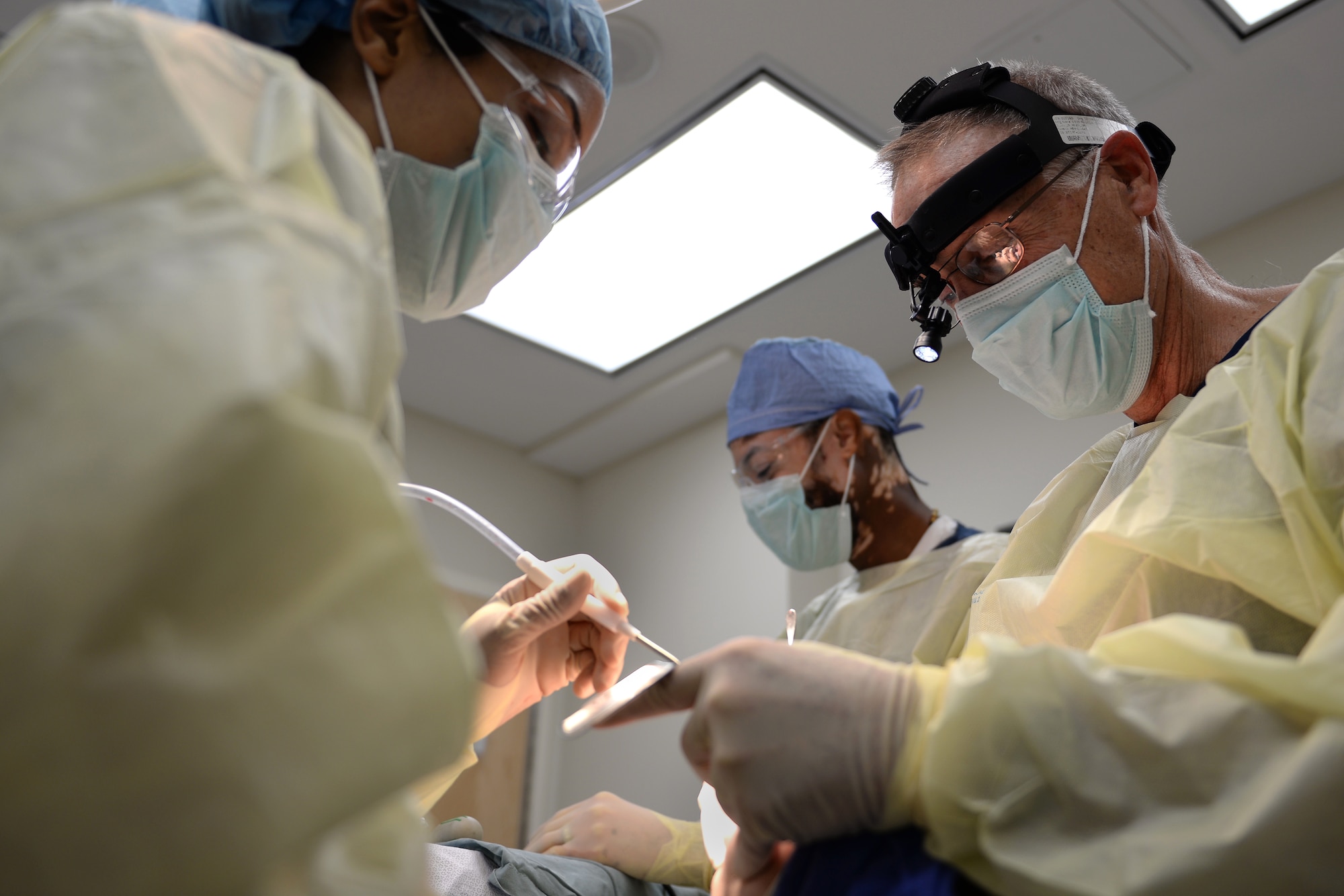 From left, U.S. Air Force Tech. Sgt. Allyson Winston, oral and maxillofacial surgery technician, Mr. Elizare Freeman, oral and maxillofacial surgery technician, Lt. Col Marshall Humes, oral and maxillofacial surgeon, all assigned to the 633rd Medical Group, prepare to remove a patient’s wisdom teeth during oral surgery at Langley Air Force Base, Va., March 17, 2016. The oral surgery clinic provides services that could save patients financially up to 30-percent than an off-base clinic. (U.S. Air Force photo by Airman 1st Class Kaylee Dubois)
