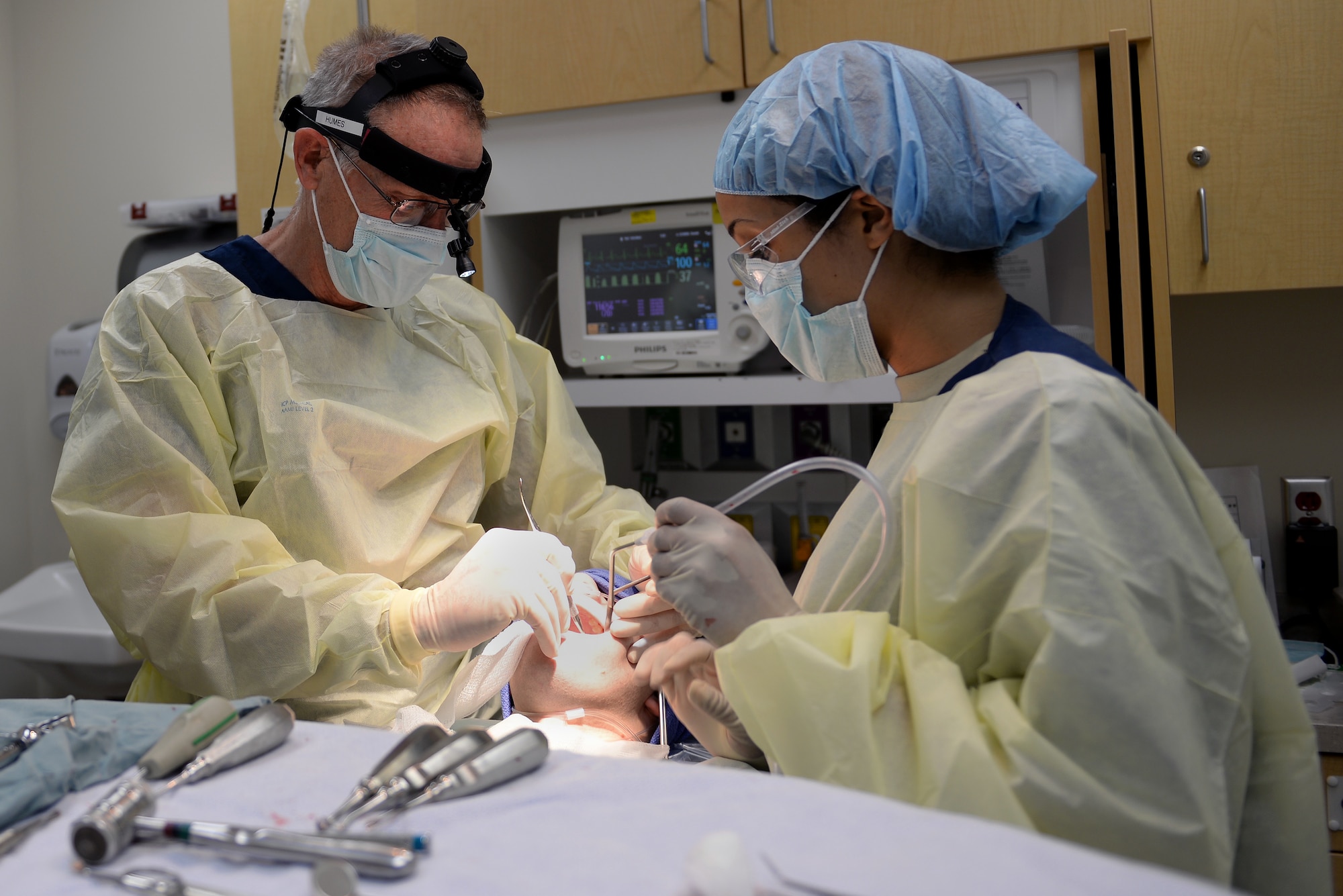 U.S. Air Force Lt. Col Marshall Humes and Tech. Sgt. Allyson Winston, oral and maxillofacial surgeon and technician, assigned to the 633rd Medical Group, prepare to remove a patient’s wisdom teeth during oral surgery at Langley Air Force Base, Va., March 17, 2016. Specializing in the face, jaw and mouth, Humes can provide services that would typically send Service members to an off-base provider for surgeries. (U.S. Air Force photo by Airman 1st Class Kaylee Dubois)