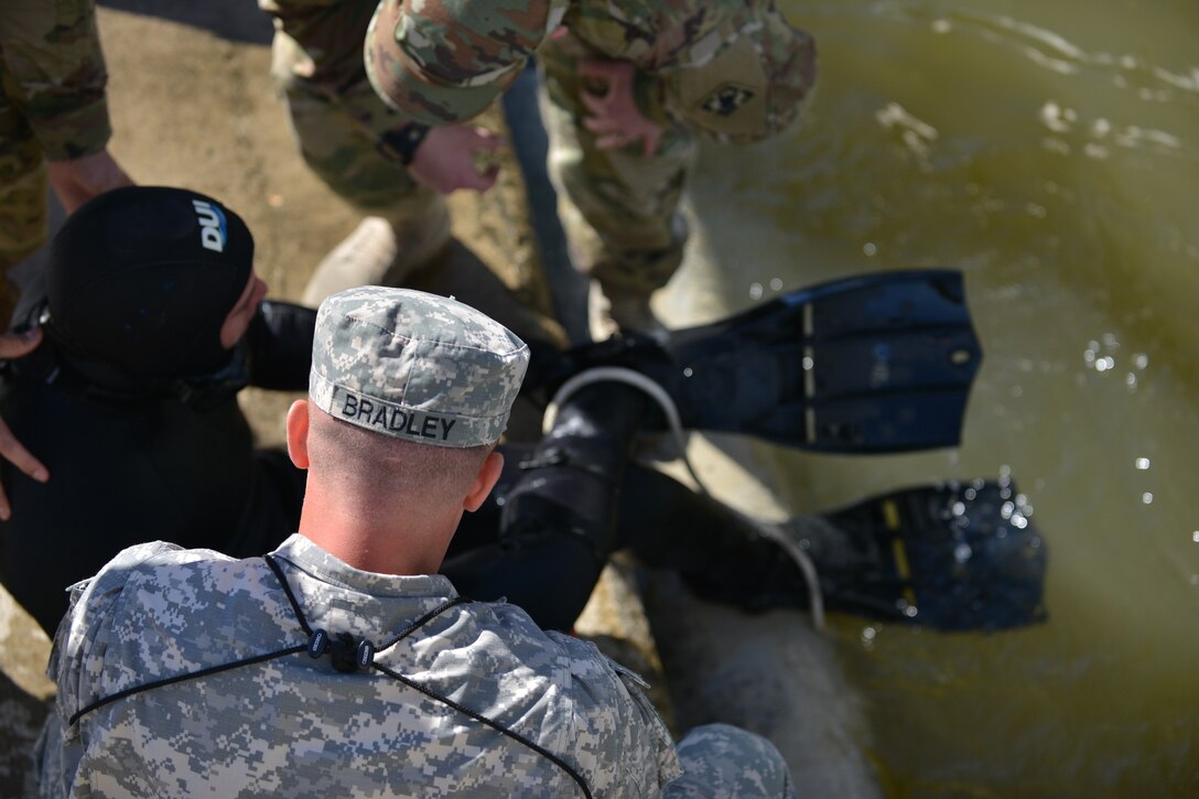 U.S. Soldiers check Sgt. Gordon Yeaple, a salvage diver and noncommissioned officer in charge with the 569th Engineer Dive Detachment, during a Salvage Dive Rodeo training at Fort Eustis, Va., March 18, 2016. Yeaple’s simulated taking on bad air during a dive and was rendered unconscious for the purposes of the upgrade task training exercise. (U.S. Air Force photo by Staff Sgt. Natasha Stannard)