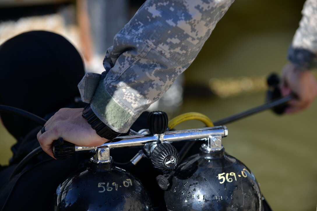 A U.S. Army diver conducts an equipment safety check before a fellow diver with the 569th Engineer Dive Detachment goes into the water at Fort Eustis, Va., March 18, 2016.  Safety checks are conducted on all equipment before each dive to mitigate any possible risk. (U.S. Air Force photo by Staff Sgt. Natasha Stannard)   
