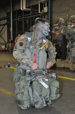 U.S. Army Reserve Maj. Christopher Schond, jumpmaster and executive officer for the 412th Civil Affairs Battalion, Whitehall, Ohio, conducts a final equipment check prior to boarding a Marine Corps KC-130J to participate in a joint service airborne paratroop drop exercise March 19 at Wright-Patterson Air Force Base, Ohio. (U.S. Air Force photo/Bryan Ripple)